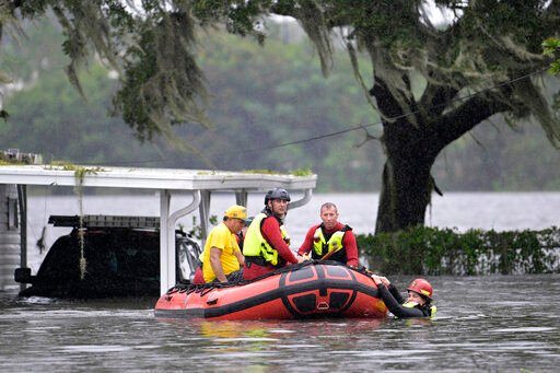 First responders with Orange County Fire Rescue use an inflatable boat to rescue a resident from a home in the aftermath of Hurricane Ian, Thursday, Sept. 29, 2022, in Orlando, Fla. (AP Photo/Phelan M. Ebenhack)    PHOTO CREDIT: Phelan M. Ebenhack