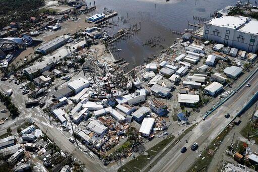 Damages boats lie on the land and water in the aftermath of Hurricane Ian, Thursday, Sept. 29, 2022, in Fort Myers, Fla. (AP Photo/Wilfredo Lee)    PHOTO CREDIT: Wilfredo Lee