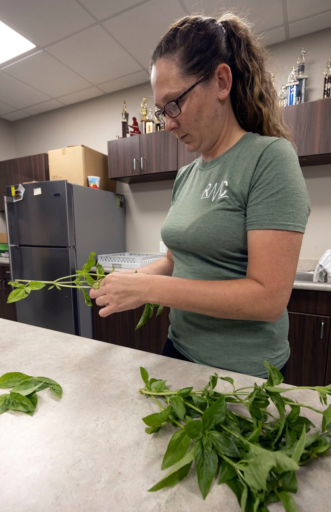 Kayla Wagener prepares basil leaves. She says they plan on returning to the Dubuque Farmers Market next season.    PHOTO CREDIT: Stephen Gassman