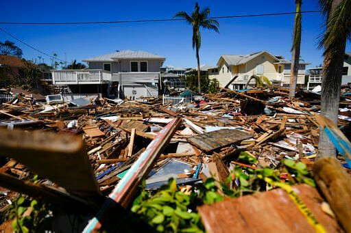 A road is completely filled with a tall pile of debris from destroyed beachfront homes and businesses, two days after the passage of Hurricane Ian, in Fort Myers Beach, Fla. Florida
