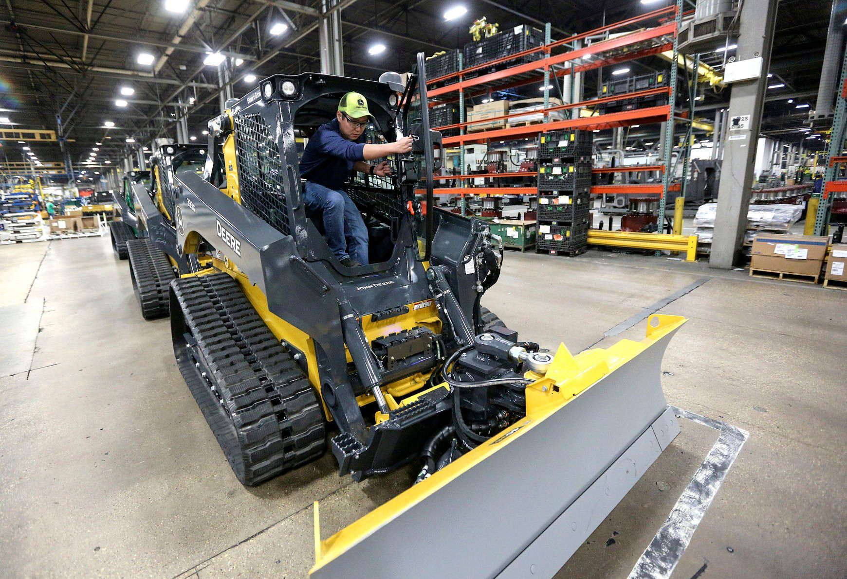 John Deere Dubuque Works employee Blake Meisner, repair coordinator and calibrator on skid-steer production line, gets into the companies newest skid-steer that features state of the art SmartGrade technology.    PHOTO CREDIT: Dave Kettering