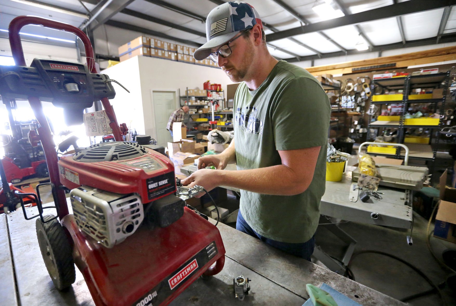 Owner Andrew Mortenson replaces a carburetor on a power washer at McGovern Hardware in Dubuque on Monday.    PHOTO CREDIT: JESSICA REILLY
