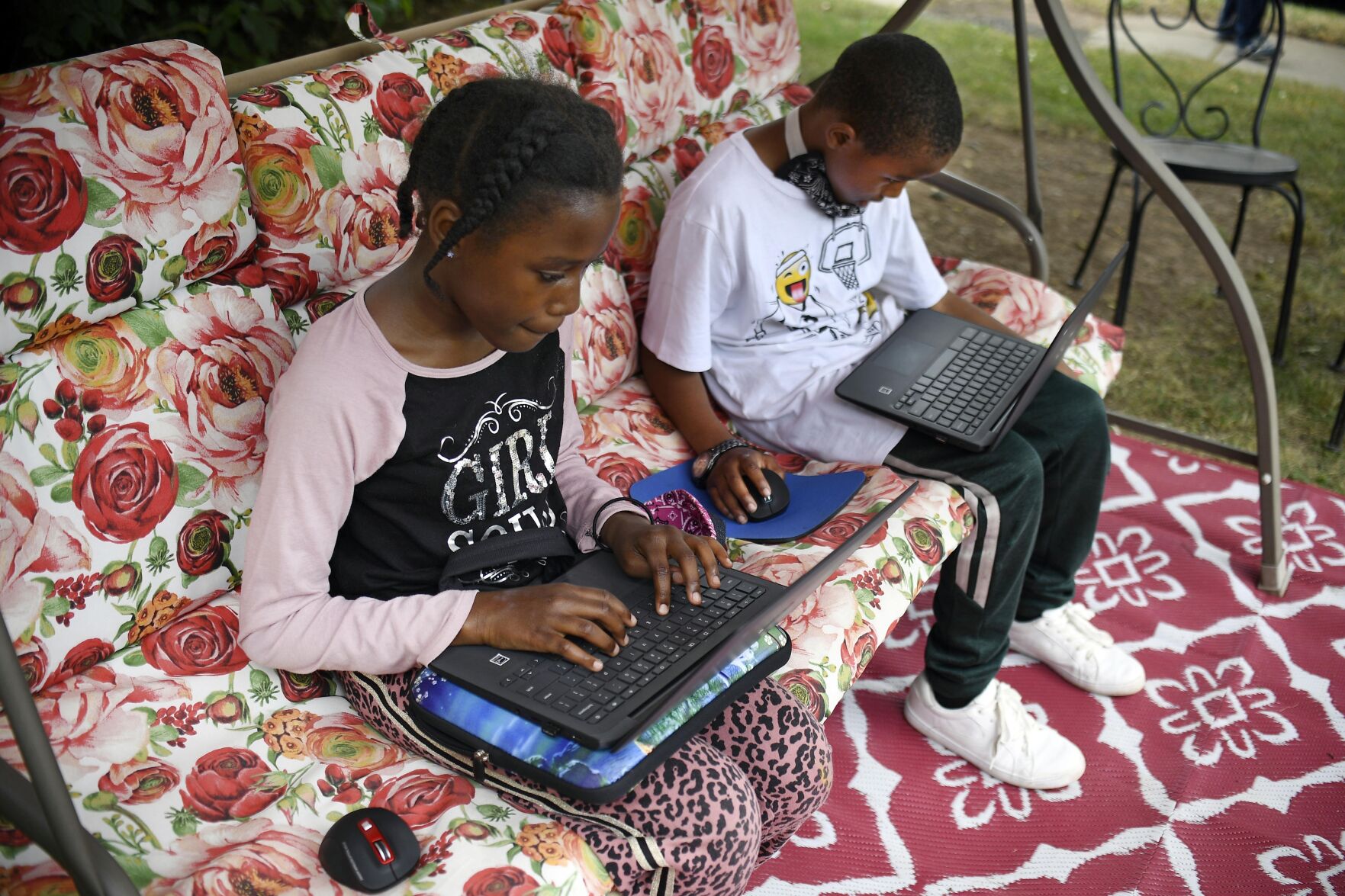 <p>FILE - Fourth-grader Sammiayah Thompson, left, and her brother third-grader Nehemiah Thompson work outside in their yard on laptops provided by their school system for distant learning, in Hartford, Conn., on June 5, 2020. In interviews with The Associated Press, close to 50 school leaders, teachers, parents and health officials reflected on decisions to keep students in extended online learning, especially during the spring semester of 2021. (AP Photo/Jessica Hill)</p>   PHOTO CREDIT: Jessica Hill - freelancer, FR125654 AP