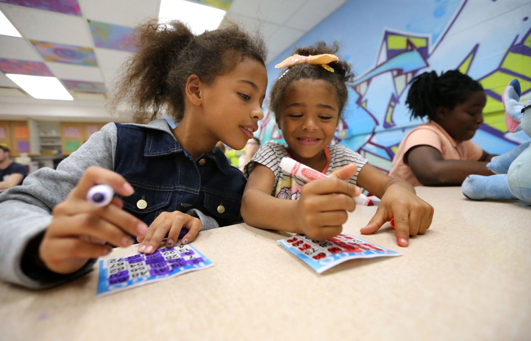 Lenora Mack (left), 7, and Ja’Kenzie Snipe, 6, play bingo at the Boys and Girls Club of Greater Dubuque on Monday.    PHOTO CREDIT: JESSICA REILLY