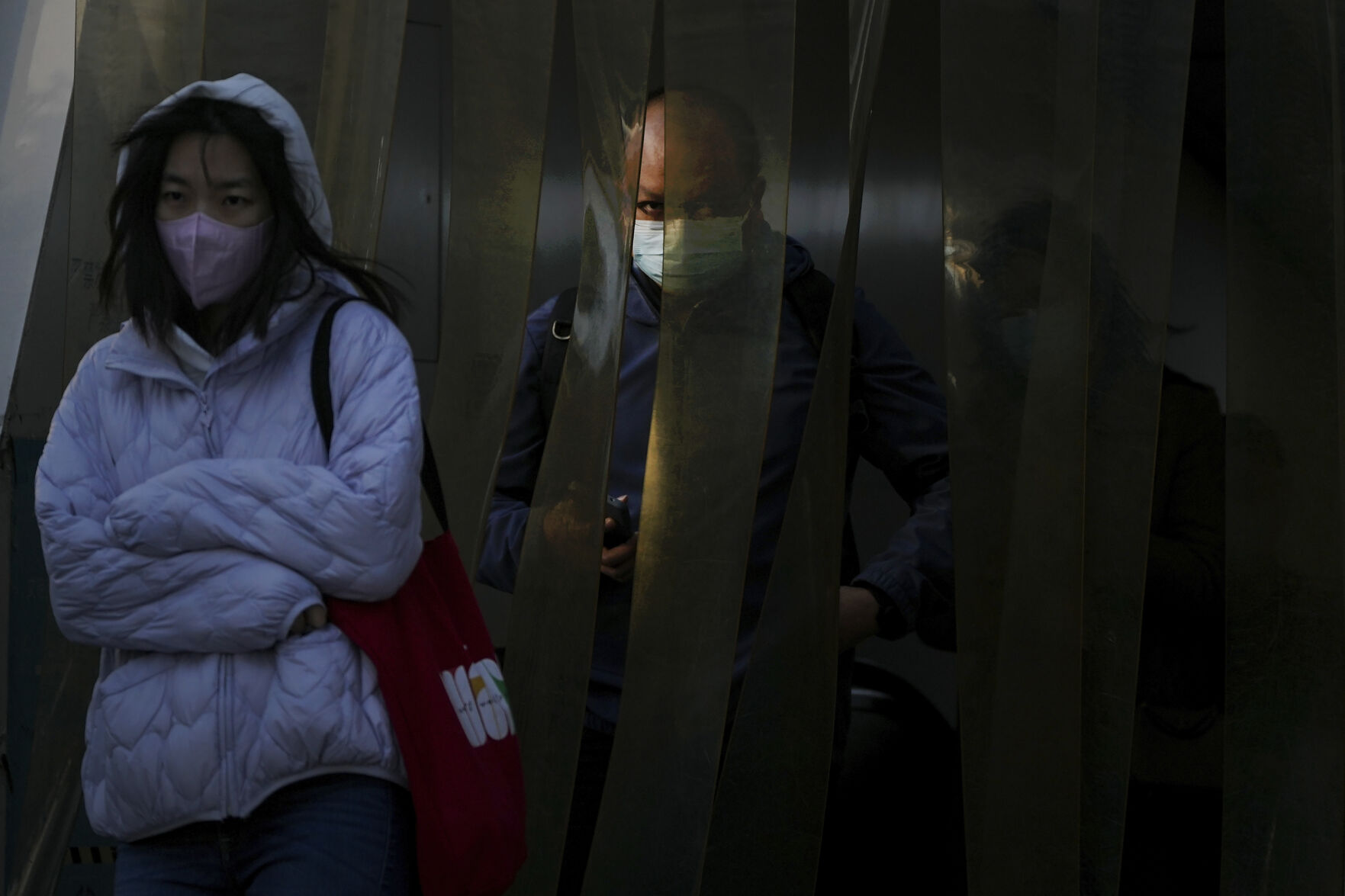 <p>Commuters wearing face masks walk through the plastic curtain as they exit a subway station in Beijing, Monday, Oct. 31, 2022. (AP Photo/Andy Wong)</p>   PHOTO CREDIT: Andy Wong - staff, AP