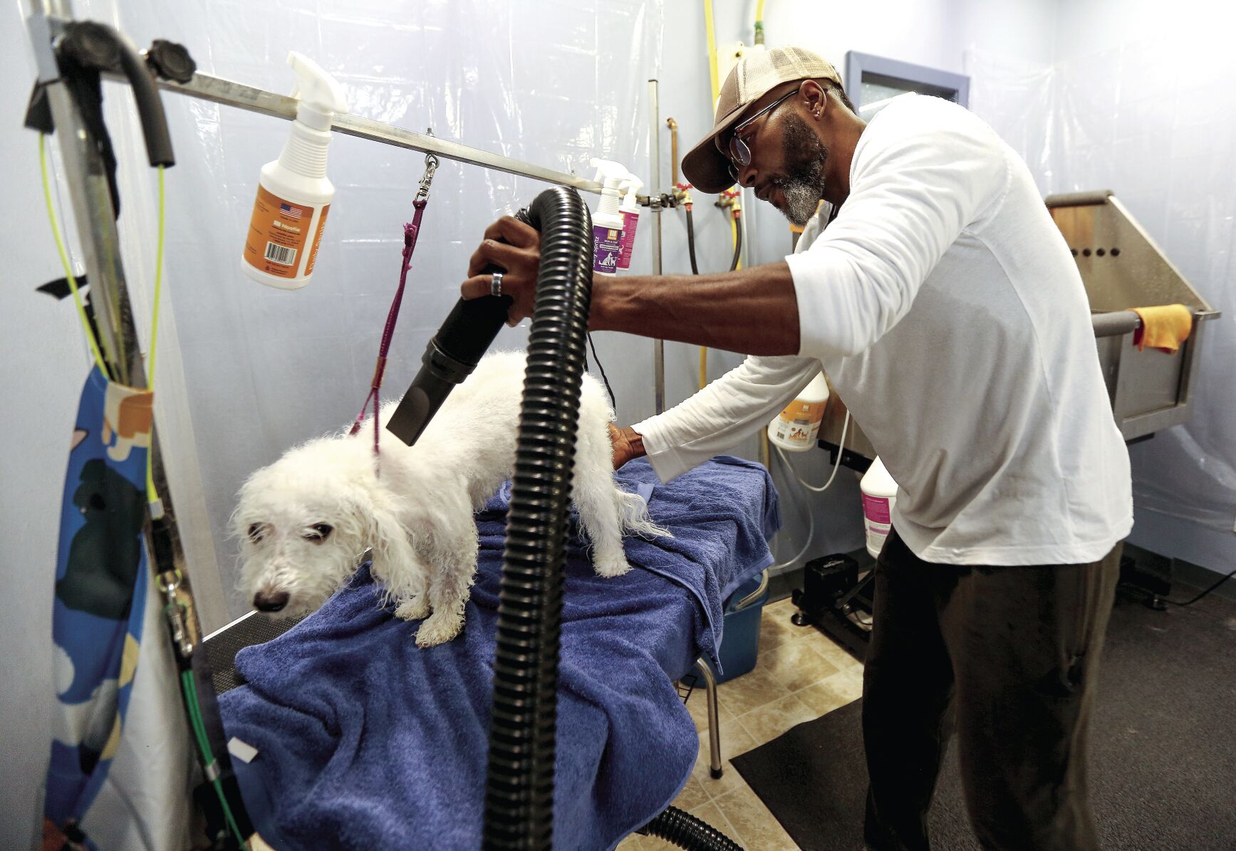 Co-owner Omar Finley dries off a dog at F.U.R. On 14th. The business is located at 490 E. 14th St. in Dubuque.    PHOTO CREDIT: Dave Kettering