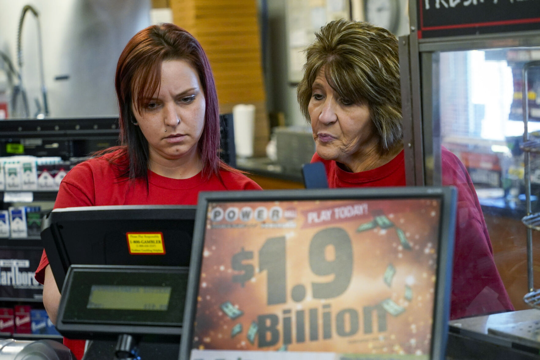 <p>Della Reminar, right, and Crystal Baptiste try to get the ticket machine to scan a card for personal selection numbers for a ticket for the Monday Powerball drawing with an annuity value of at least $1.9 billion, Monday, Nov. 7, 2022, at a convenience store in Renfrew, Pa. (AP Photo/Keith Srakocic)</p>   PHOTO CREDIT: Keith Srakocic - staff, AP