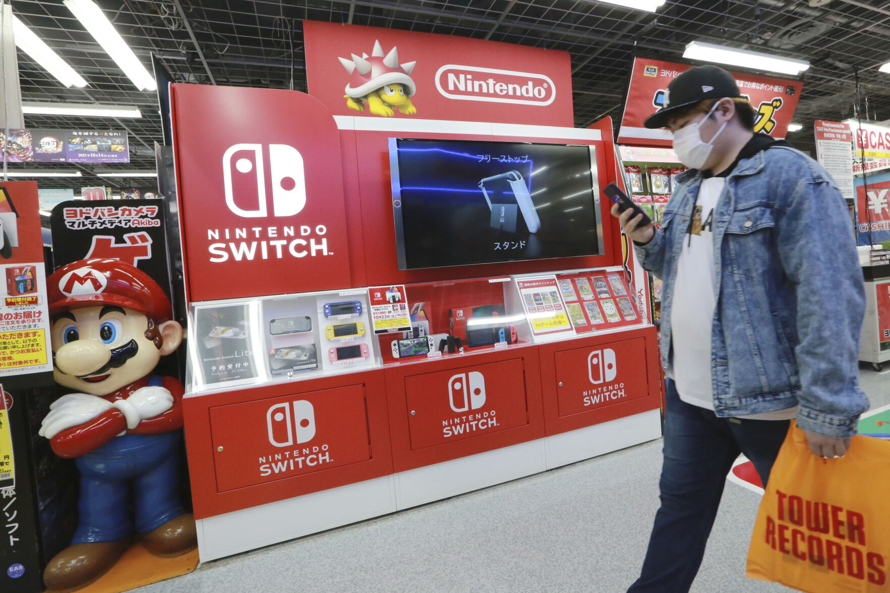 <p>A man walks an advertisement of Nintendo Switch at an electronics retail chain store in Tokyo on Oct. 13, 2021. Japanese video game maker Nintendo recorded a 34% surge in fiscal first half profits Tuesday, Nov. 8, 2022, as products for its Switch console like "Splatoon 3," a paint-shooting game, sold well. (AP Photo/Koji Sasahara)</p>   PHOTO CREDIT: Koji Sasahara 