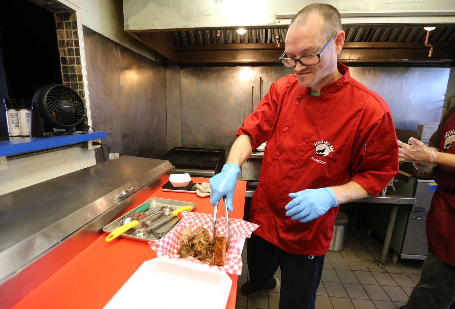Owner Jonathon Moore prepares an order at Howling BBQ in Dubuque on Wednesday.    PHOTO CREDIT: JESSICA REILLY