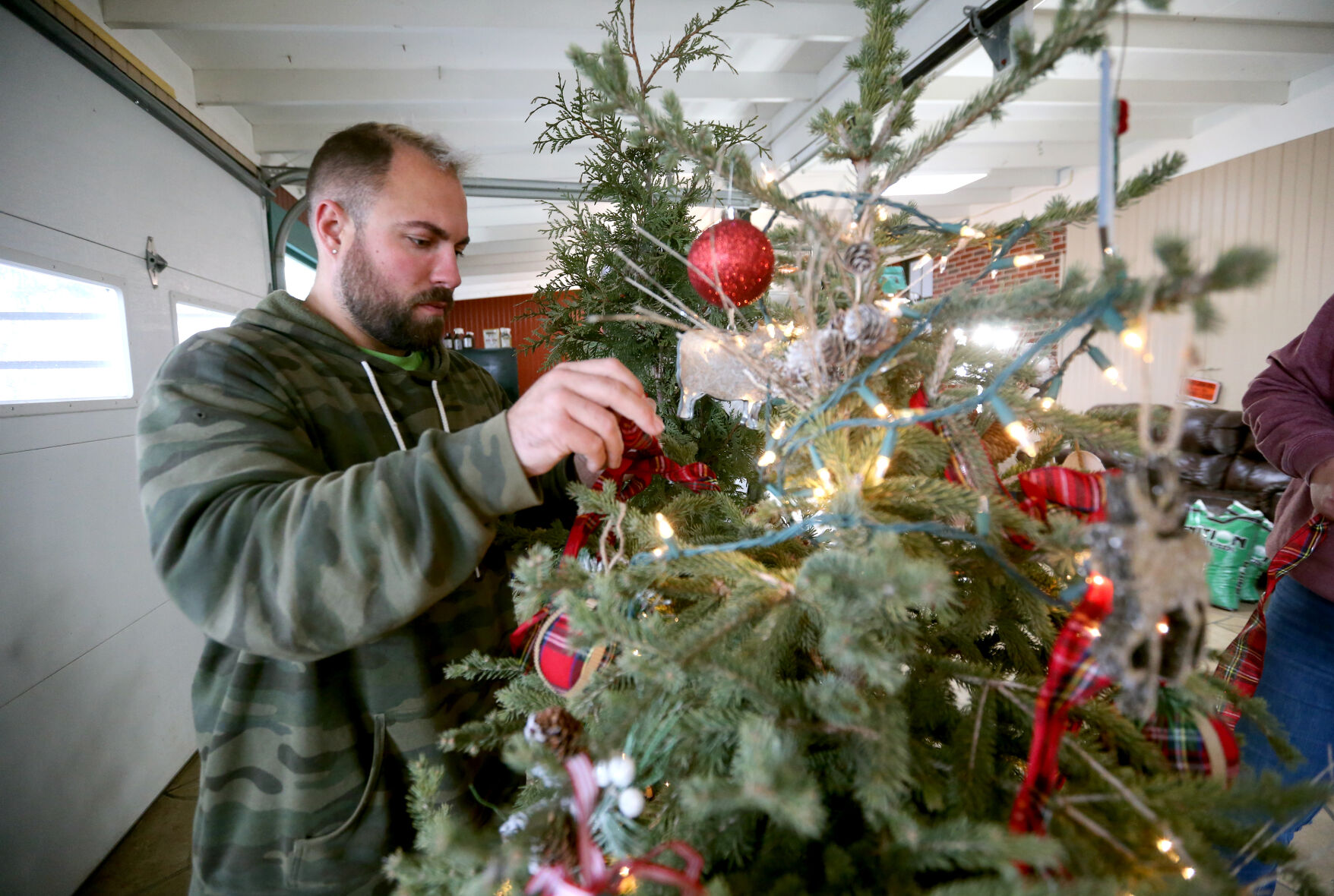 Doug Wagner Jr. decorates a tree for a display at Wagner Nursery in Asbury, Iowa.    PHOTO CREDIT: JESSICA REILLY