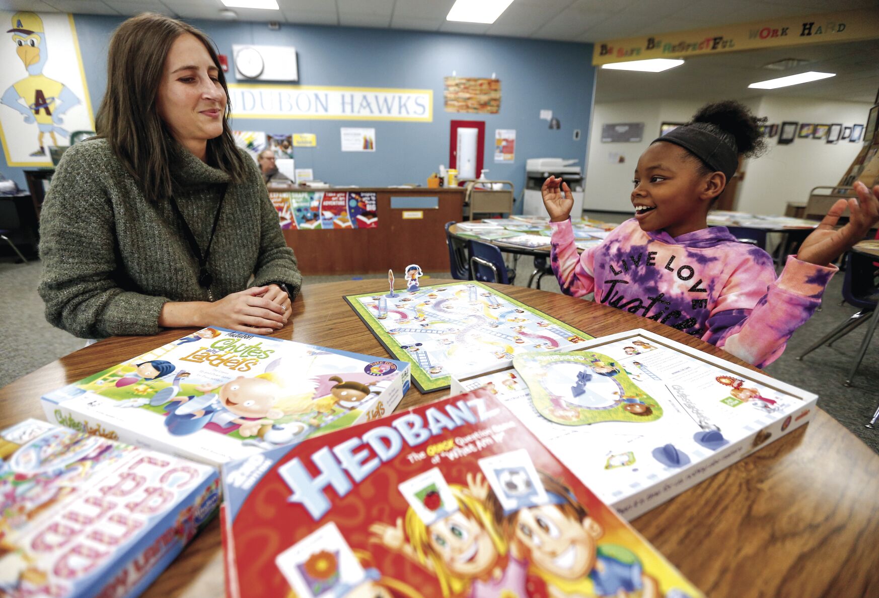 Kimmie Crump, 9, a fourth-grader at Audubon Elementary School, plays a game with mentor Morgan Weber, social media manager with Cottingham & Butler in Dubuque, on Monday.    PHOTO CREDIT: Dave Kettering