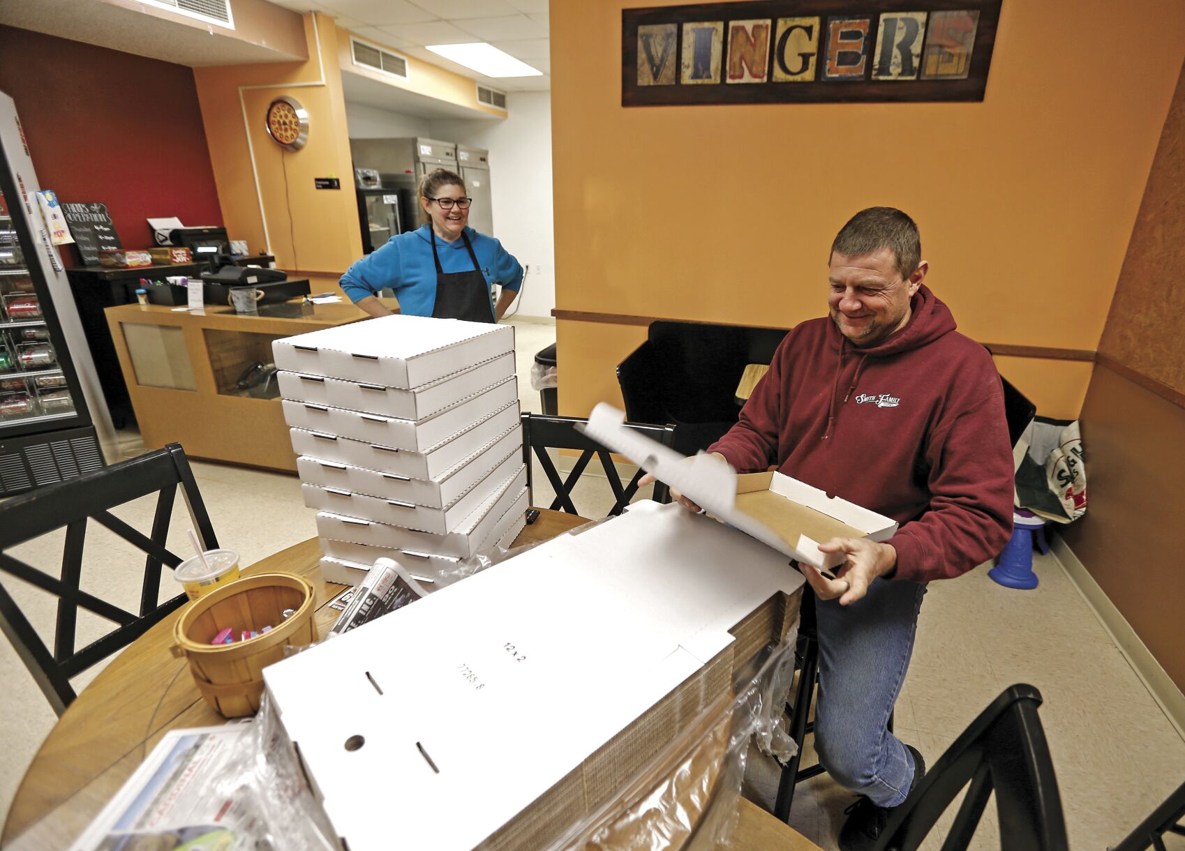Owners of Vinger’s Pizza in Darlington, Wis., Val Smith and her husband, Steve, get boxes ready before opening Saturday.    PHOTO CREDIT: Dave Kettering