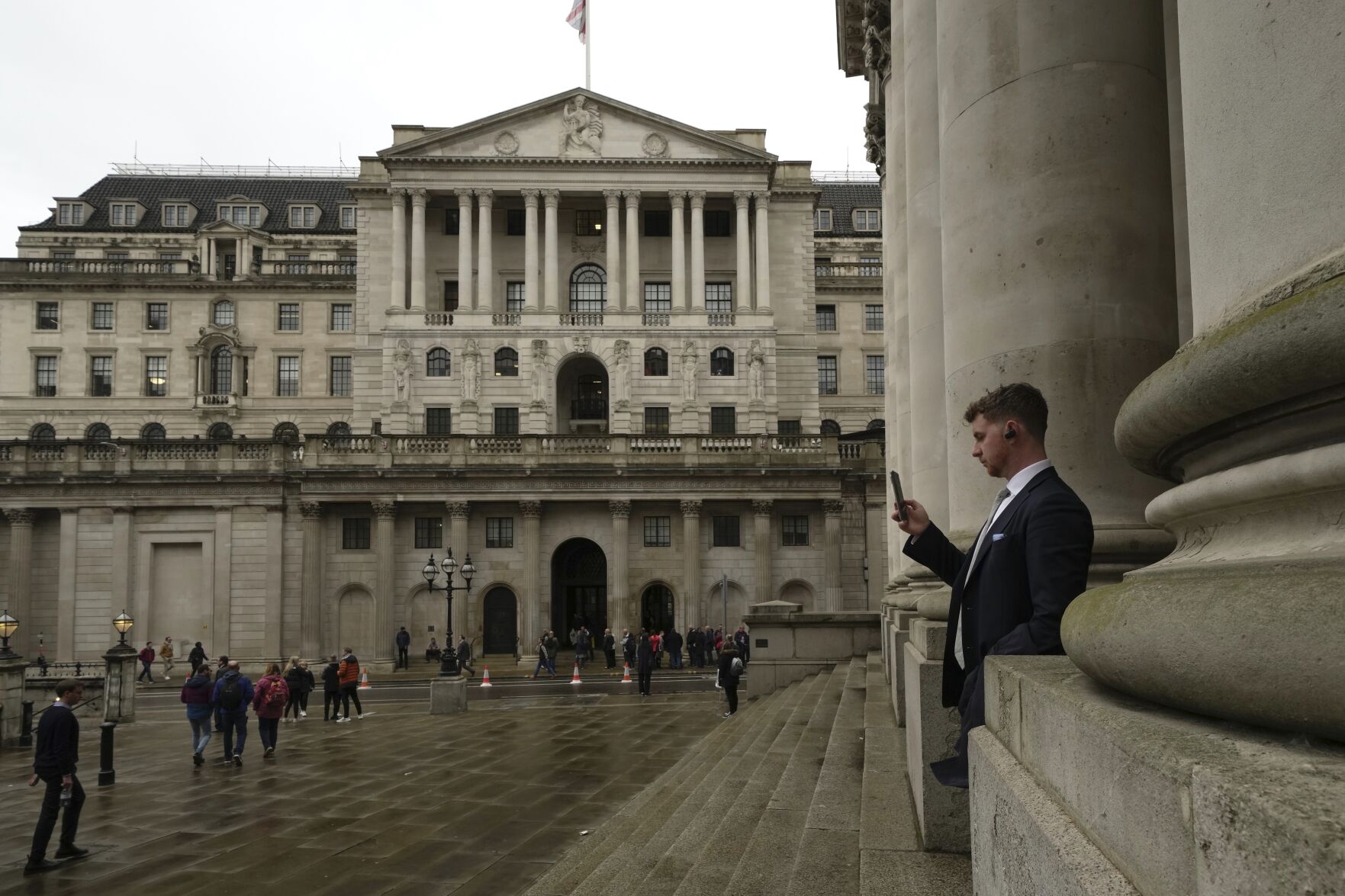 <p>FILE - A man walks in front of the Bank of England, at the financial district in London, on Nov. 3, 2022. Britain’s economy shrank in the three months through October, confirming the toll that rampant inflation and rising interest rates are having on business and industry. (AP Photo/Kin Cheung, File)</p>   PHOTO CREDIT: Kin Cheung 