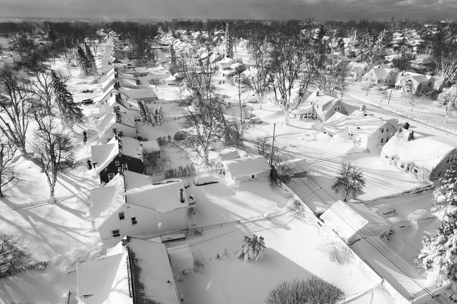 <p>In this drone image, snow blankets a neighborhood, Sunday, Dec. 25, 2022, in Cheektowaga, N.Y. Millions of people hunkered down against a deep freeze Sunday morning to ride out the frigid storm that has killed at least 24 people across the United States and is expected to claim more lives after trapping some residents inside houses with heaping snow drifts and knocking out power to several hundred thousand homes and businesses.(John Waller via AP)</p>   PHOTO CREDIT: John Waller - handout one time use, John Waller