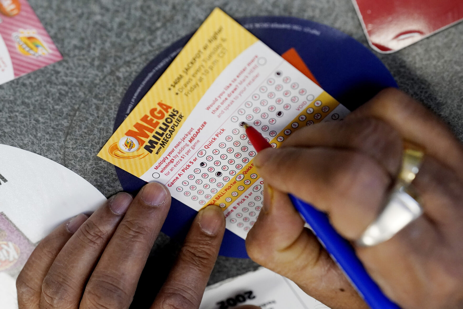 <p>FILE - A customer fills out a Mega Millions lottery ticket at a convenience store in Northbrook, Ill., on Jan. 6, 2021. The holiday shopping season, for Mega Millions lottery ticket buyers, at least, is ramping up as officials say the estimated jackpot for the drawing the night of Tuesday, Dec. 27, 2022, has surpassed half a billion dollars. (AP Photo/Nam Y. Huh, File)</p>   PHOTO CREDIT: Nam Y. Huh 