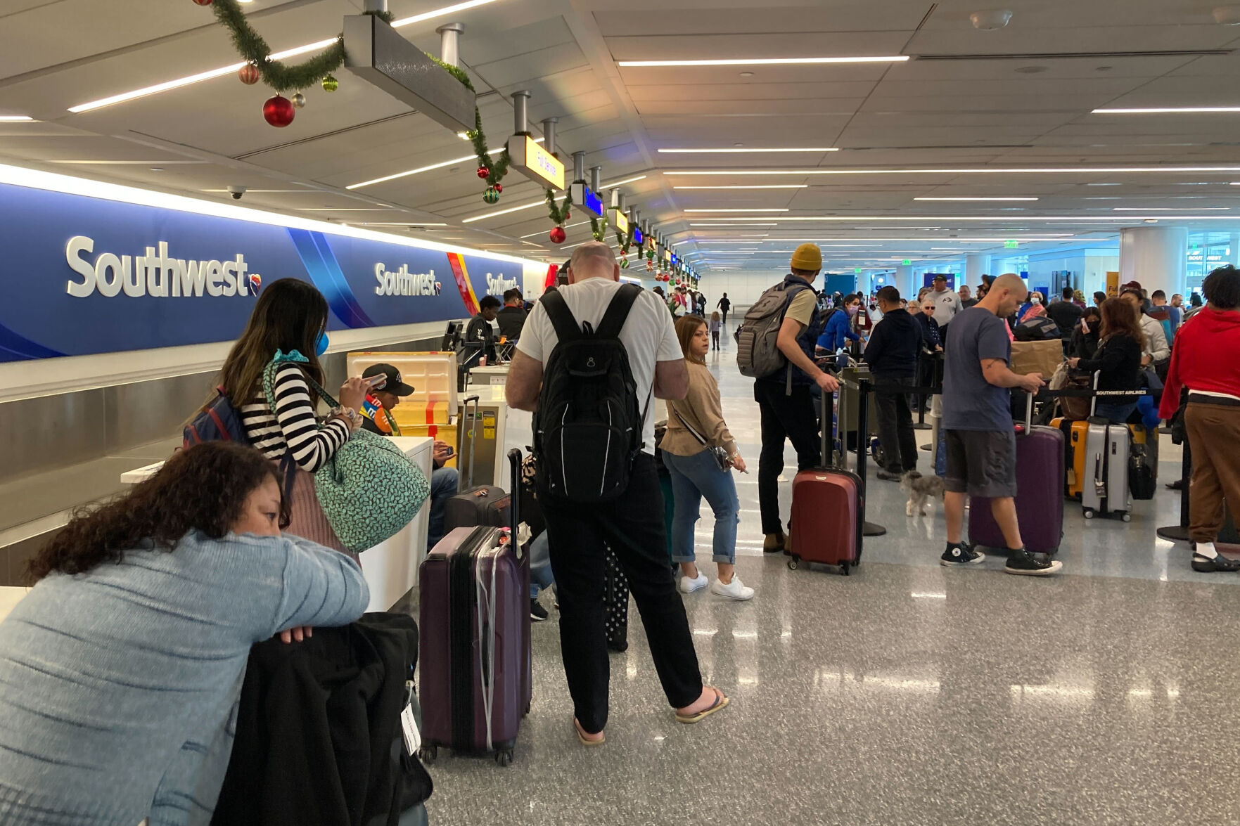 <p>Travelers wait at a Southwest Airlines baggage counter to retrieve their bags after canceled flights at Los Angeles International Airport, Monday, Dec. 26, 2022, in Los Angeles. (AP Photo/Eugene Garcia)</p>   PHOTO CREDIT: Eugene Garcia 