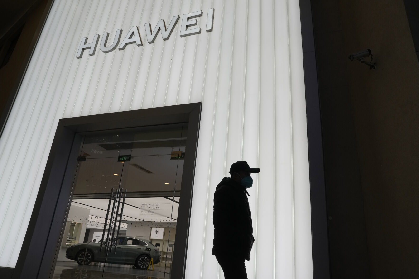 <p>A man is silhouetted outside a Huawei retail store in Beijing, Friday, Dec. 30, 2022. Chinese technology giant Huawei says it has pulled itself out of "crisis mode" following years of U.S. restrictions that have stifled its sales in overseas markets, though its revenue for 2022 did not grow from a year earlier. (AP Photo/Ng Han Guan)</p>   PHOTO CREDIT: Ng Han Guan - staff, AP