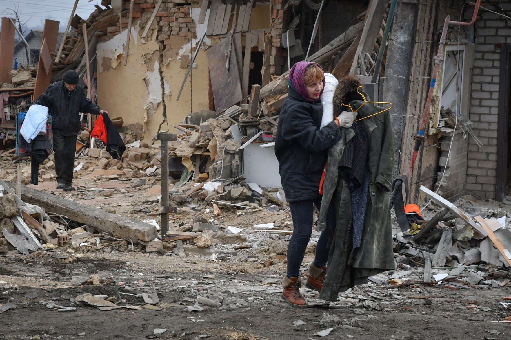 <p>Local residents carry their belongings as they leave their home ruined in the Saturday Russian rocket attack in Zaporizhzhya, Ukraine, Sunday, Jan. 1, 2023. (AP Photo/Andriy Andriyenko)</p>   PHOTO CREDIT: Andriy Andriyenko 