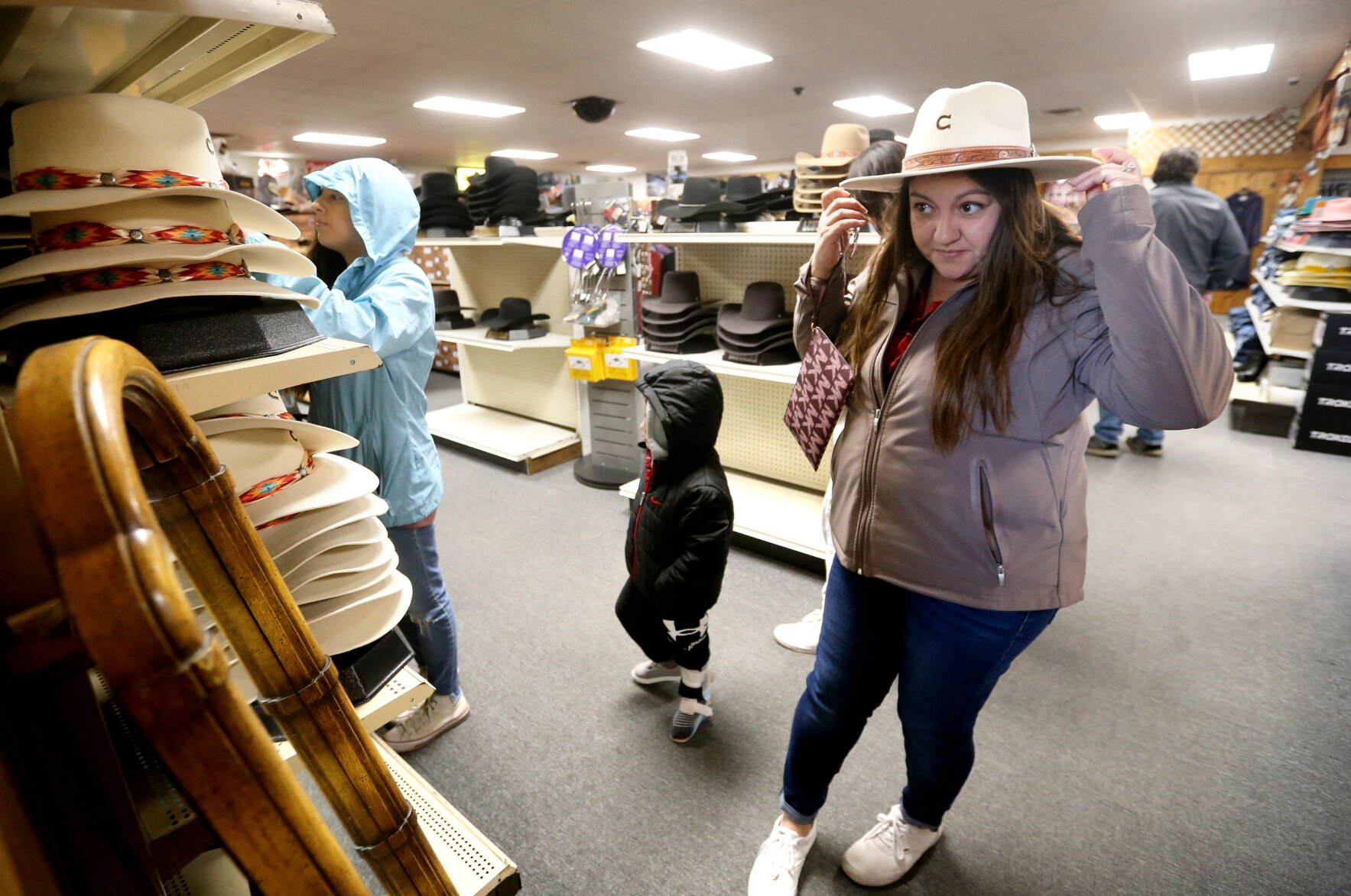 Irene Schaefer, of Johnson Creek, Wis., shops for hats at Longhorn Saddlery and Western Wear in Dubuque. The store offers shoppers a taste of classic Western charm.    PHOTO CREDIT: JESSICA REILLY