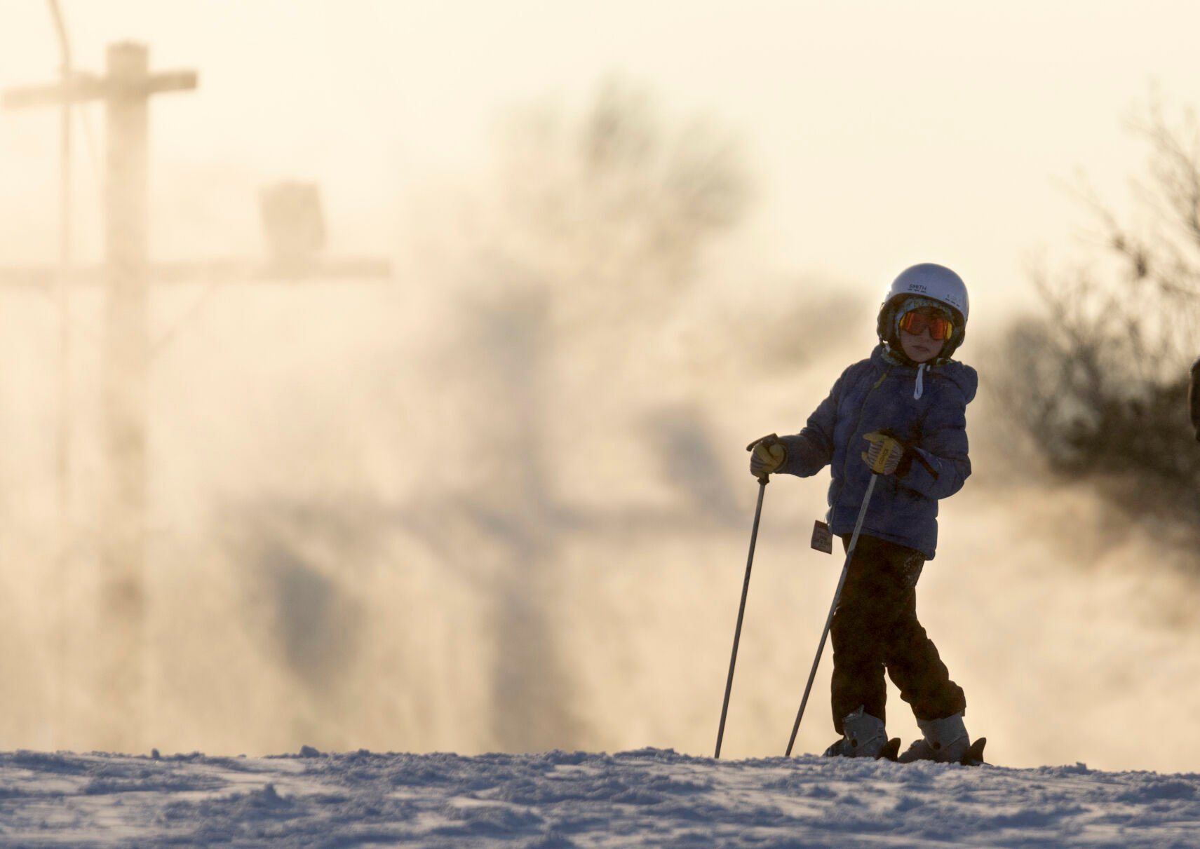 A young skier on top of one of the runs as man-made snow swirls in the background.    PHOTO CREDIT: Stephen Gassman