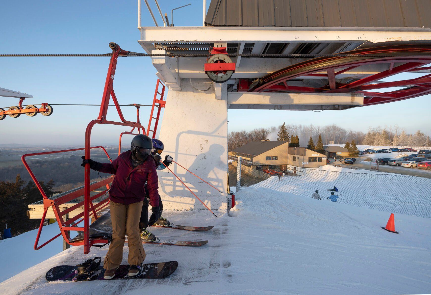 A young skier and snowboarder exit the triple chairlift at Sundown Mountain Resort in Dubuque on Friday, Jan. 6, 2023    PHOTO CREDIT: Stephen Gassman