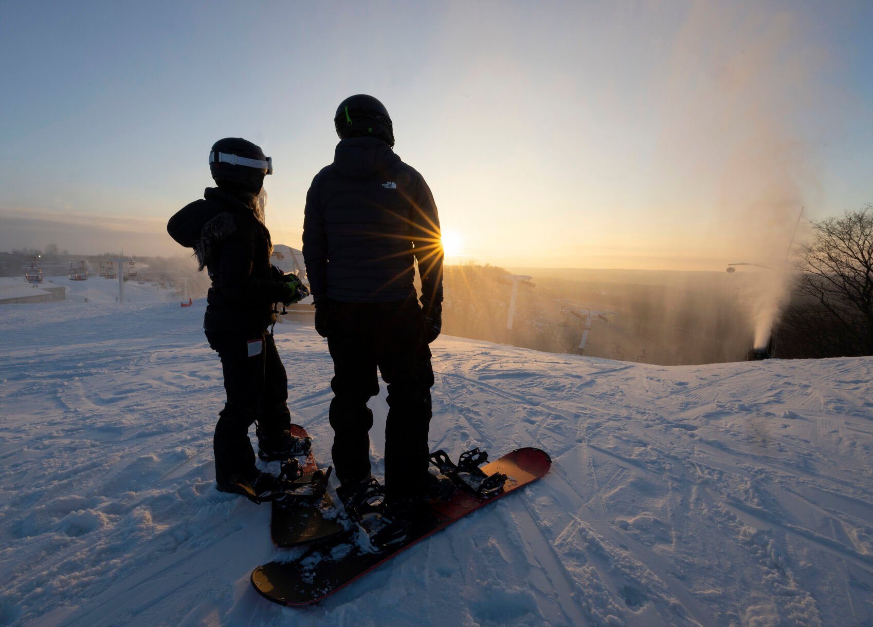 Abbie Janik (left) and Trevor Burrows, both of North Liberty, Iowa, look down the slopes at Sundown Mountain Resort in Dubuque on Friday, Jan. 6, 2023    PHOTO CREDIT: Stephen Gassman