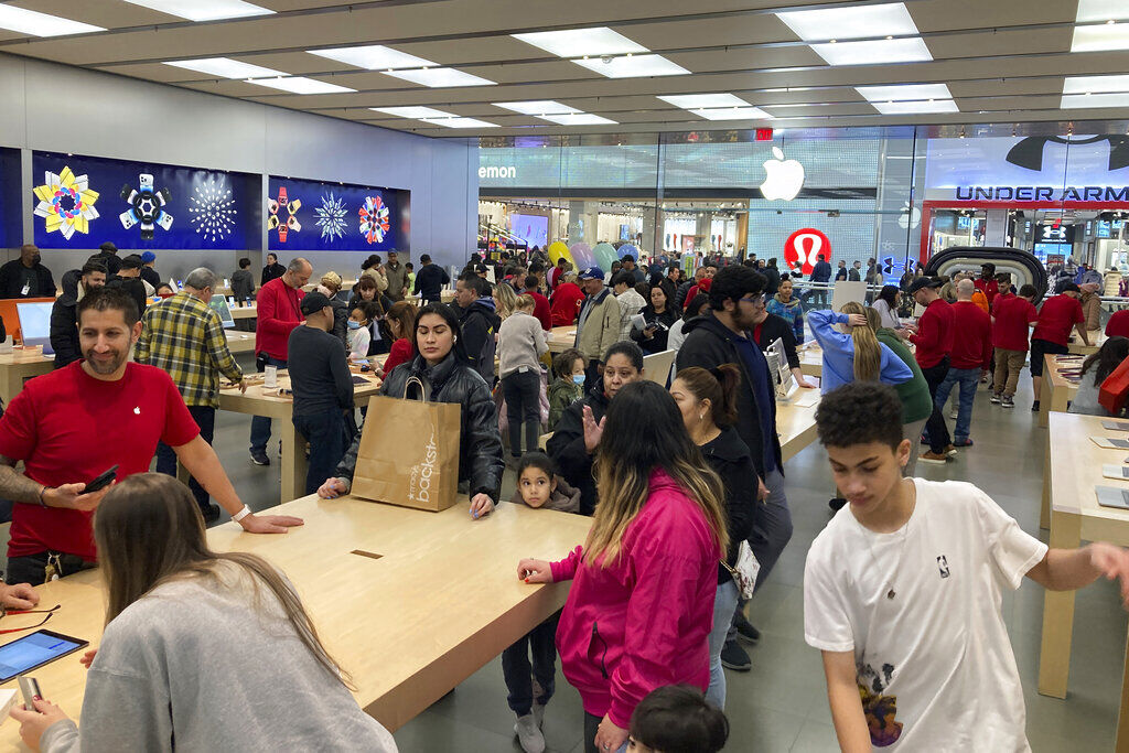 People shop at an Apple store in the Westfield Garden State Plaza mall in Paramus, N.J. Americans cut back on spending in December, the second consecutive month they’ve done so, underscoring how inflation and the rising cost of using credit cards slowed consumer activity over the crucial holiday shopping season.     PHOTO CREDIT: Ted Shaffrey