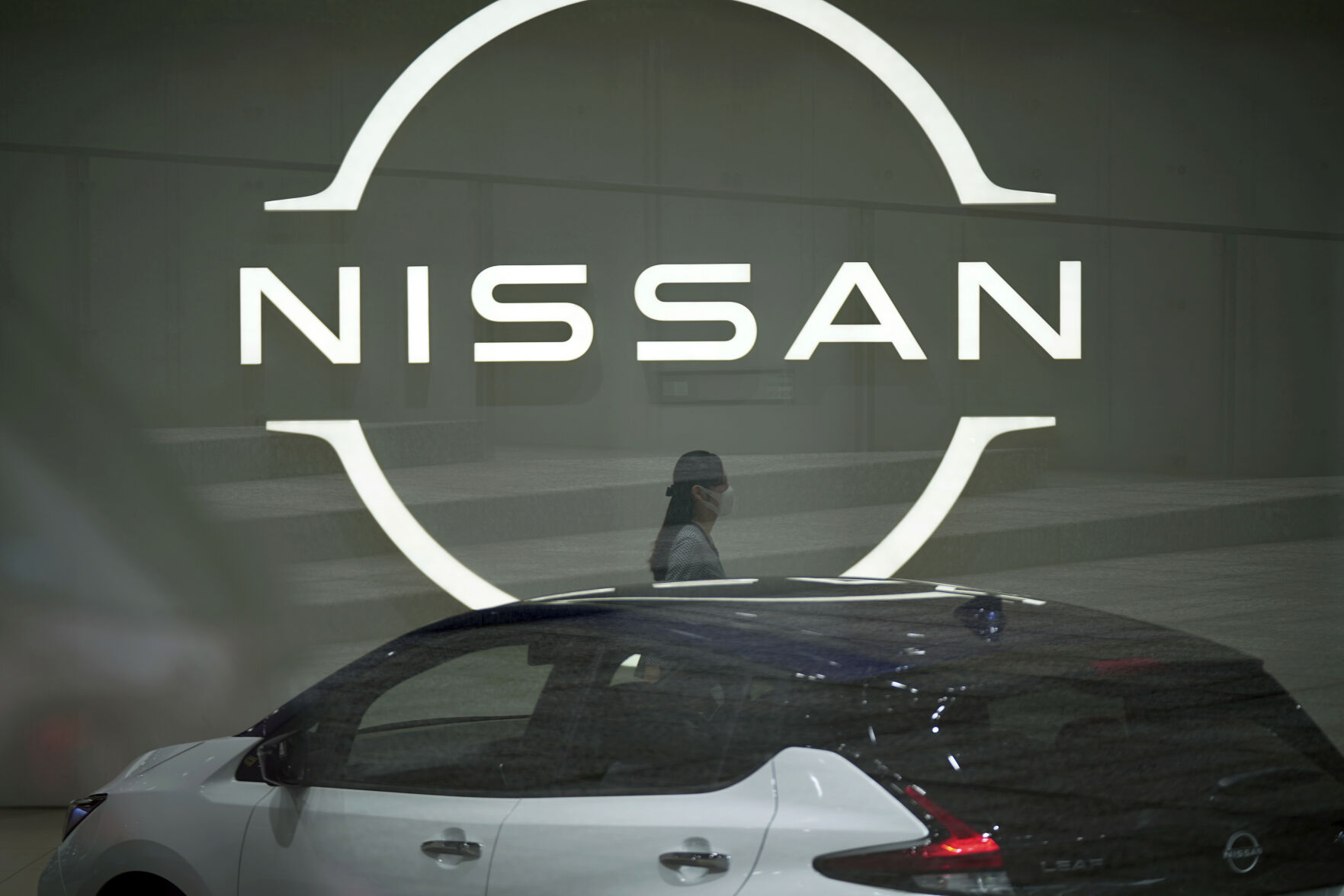 <p>FILE - A staff walking near a Nissan logo at Nissan headquarters is seen though a window on May 12, 2022, in Yokohama near Tokyo. Nissan and Renault have changed their mutual cross-shareholdings to the same 15%, ironing out a source of conflict in the Japan-French auto alliance. (AP Photo/Eugene Hoshiko, File)</p>   PHOTO CREDIT: Eugene Hoshiko 