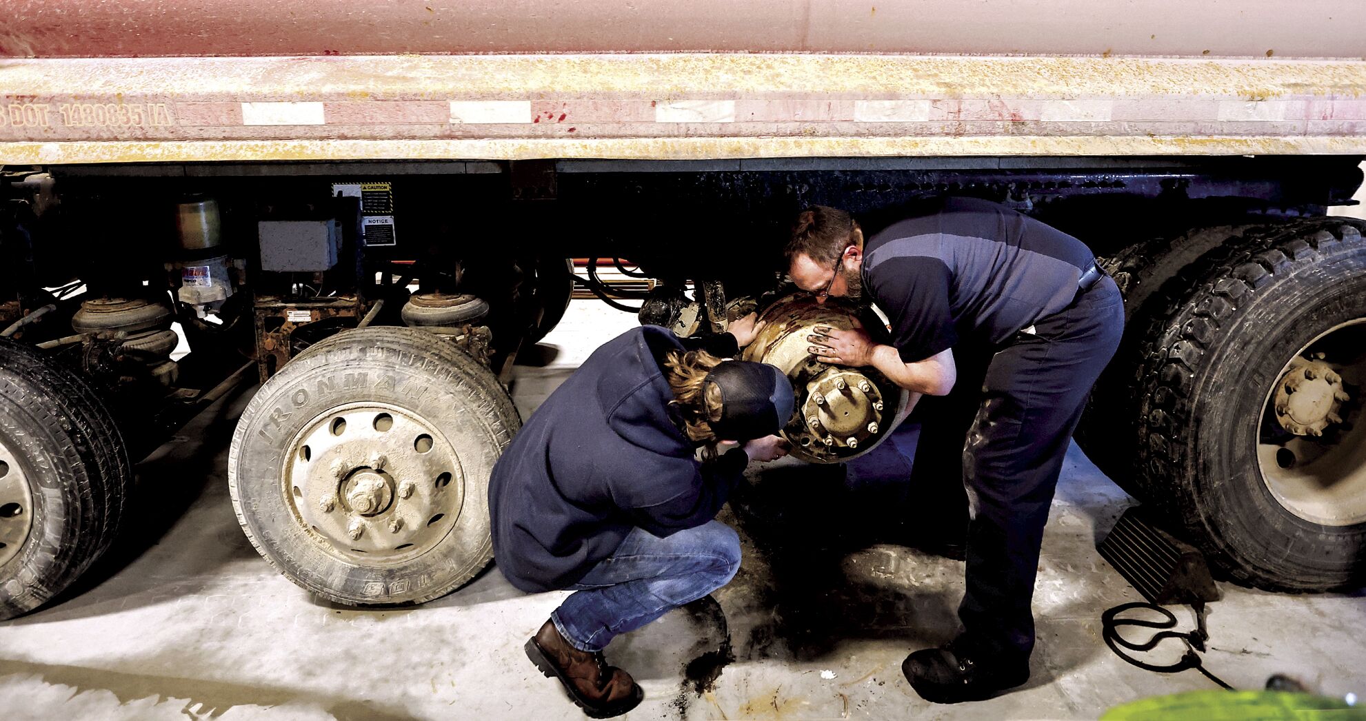 Clarence Trumm (left) and Jason Mootz work to replace brakes on a truck at Thompson Truck & Trailer in Dubuque on Friday.    PHOTO CREDIT: JESSICA REILLY