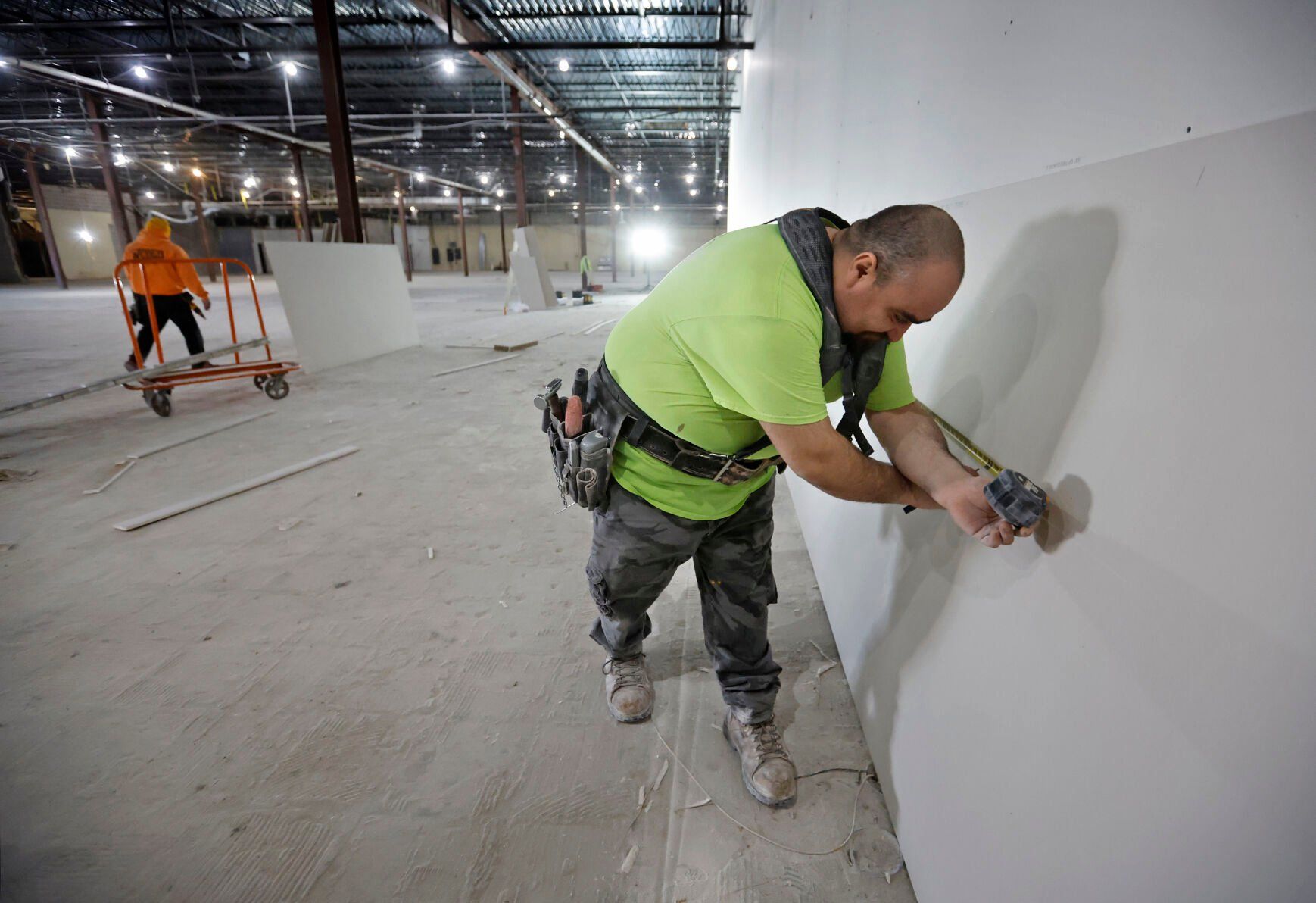 Osciel Gonzalez, with Welborn Painting and Drywall in Dubuque, measures drywall at Kennedy Mall in Dubuque on Monday, Feb. 20, 2023. The work is part of a remodel of the former Younkers women