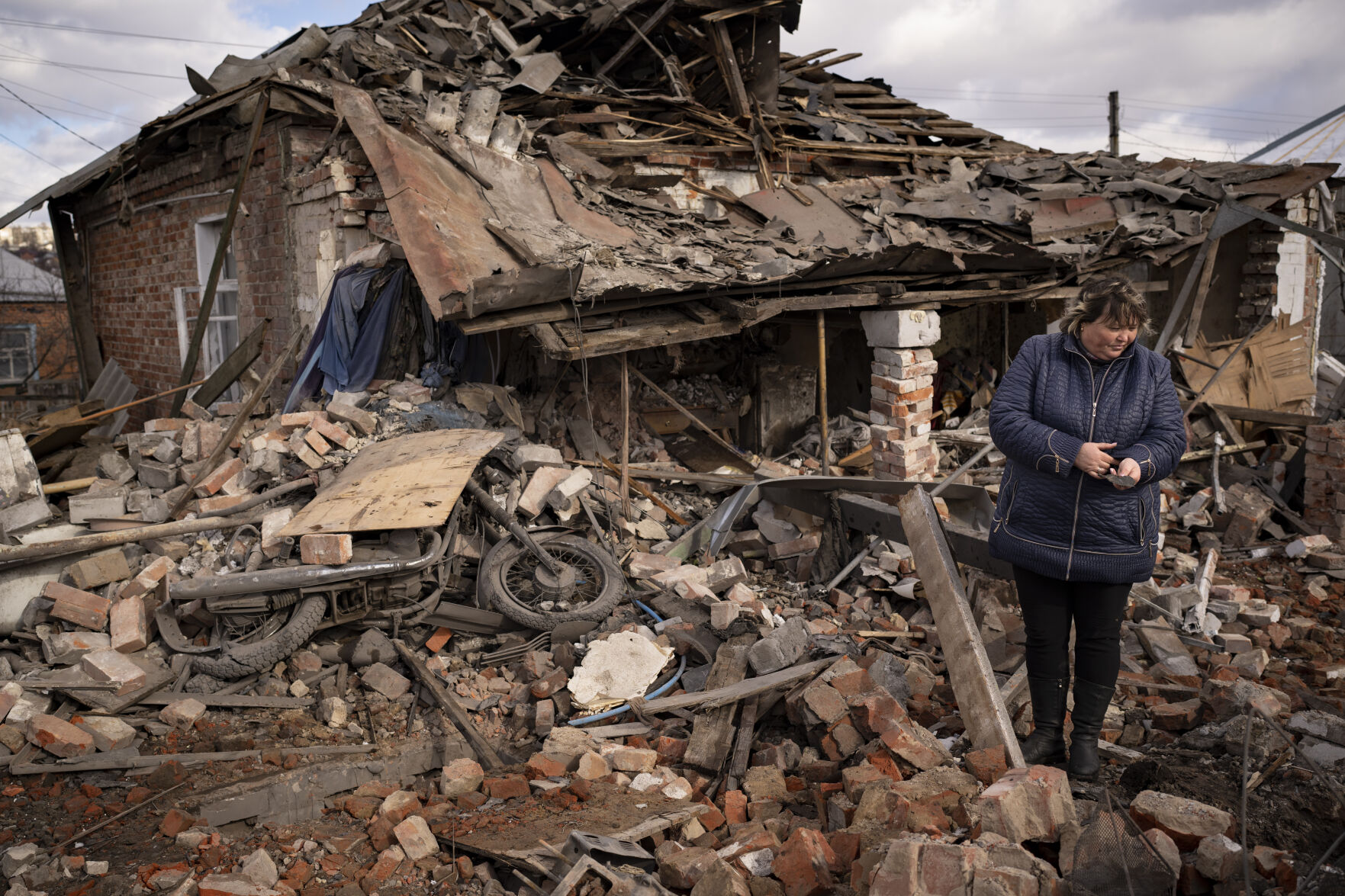<p>FILE - A woman holds a piece of shrapnel standing in the rubble of a house where Ukrainian servicemen were sheltering which destroyed by a Russian S-300 rocket strike, in Kupiansk, Ukraine, Monday, Feb. 20, 2023. Grueling artillery battles have stepped up in recent weeks in the vicinity of Kupiansk, a strategic town on the eastern edge of Kharkiv province by the banks of the Oskil River as Russian attacks intensifying in a push to capture the entire industrial heartland known as the Donbas, which includes the Donetsk and the Luhansk provinces. (AP Photo/Vadim Ghirda, File)</p>   PHOTO CREDIT: Vadim Ghirda 