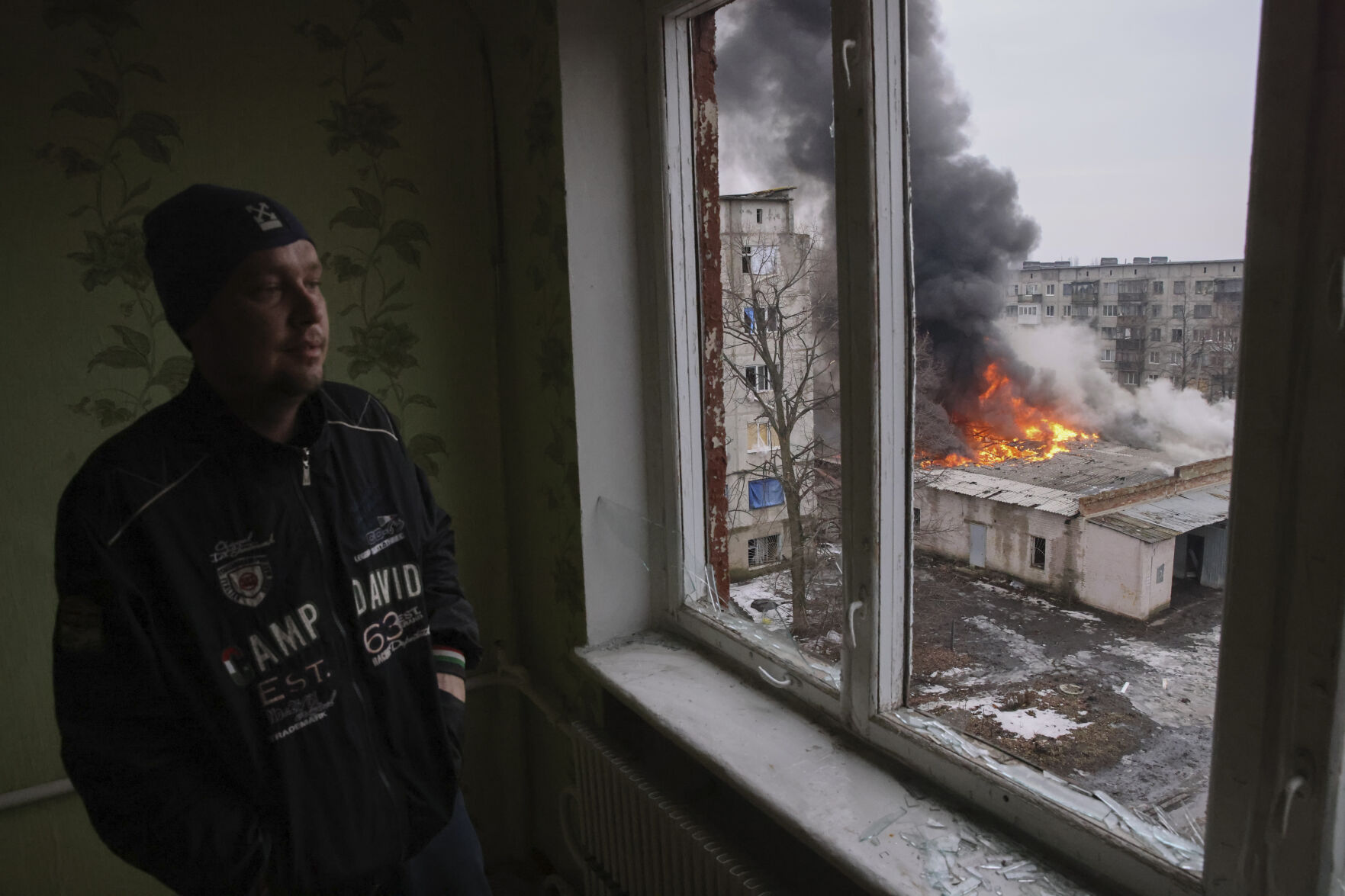 <p>A local resident stands at the window as smoke raises from the burning building after the Russian shelling in the town of Chasiv Yar, the site of the heaviest battles with the Russian troops, Donetsk region, Ukraine, Monday, Feb. 27, 2023. (AP Photo/Yevhen Titov)</p>   PHOTO CREDIT: Yevhen Titov - stringer, AP