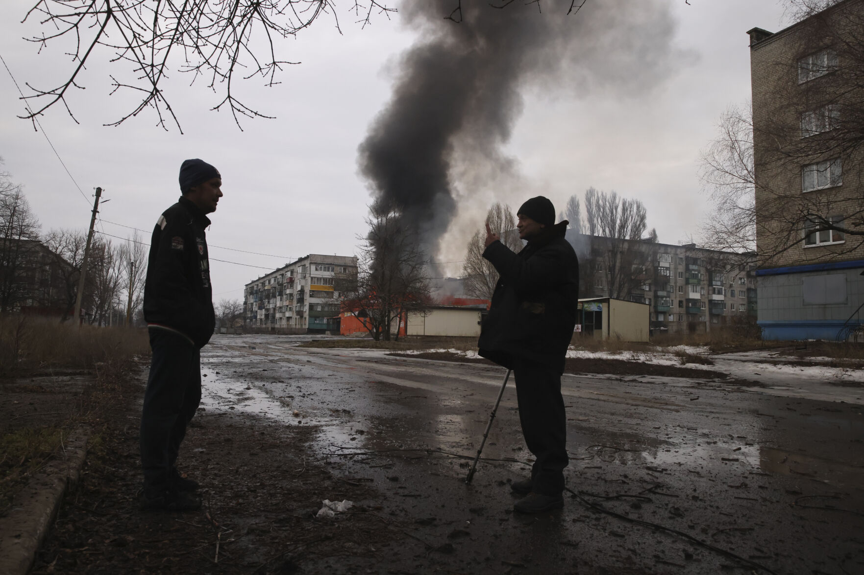 <p>Local residents talk against the background of a building burning after the Russian shelling in the town of Chasiv Yar, the site of the heaviest battles with the Russian troops, Donetsk region, Ukraine, Monday, Feb. 27, 2023. (AP Photo/Yevhen Titov)</p>   PHOTO CREDIT: Yevhen Titov - stringer, AP