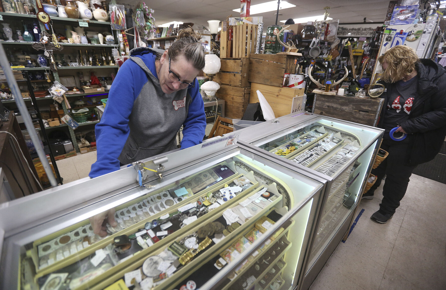 Co-owner of Shaggy’s Indoor Flea Market Lisa Hammel arranges items in a display case in the Dubuque store located off of North Crescent Ridge.    PHOTO CREDIT: Dave Kettering