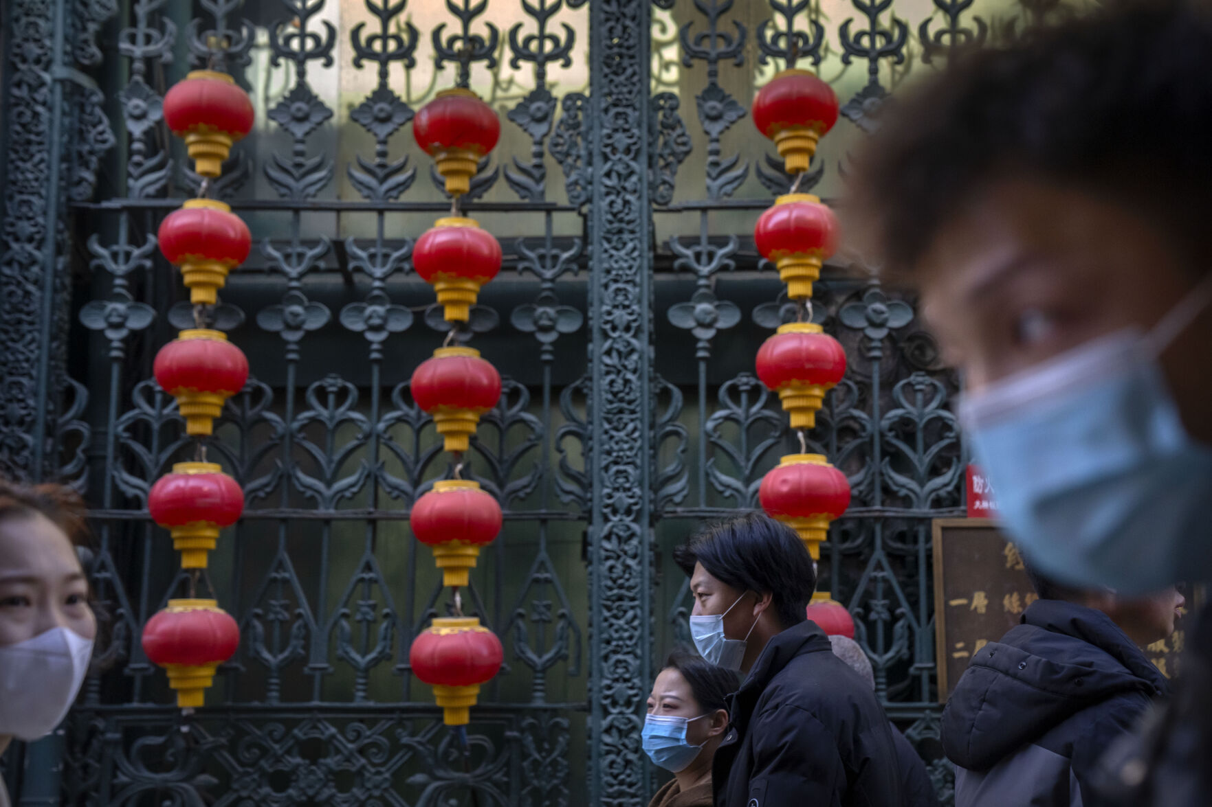 <p>People wearing face masks walk past rows of lanterns at a tourist shopping street in Beijing, Tuesday, Feb. 28, 2023. (AP Photo/Mark Schiefelbein)</p>   PHOTO CREDIT: Mark Schiefelbein 