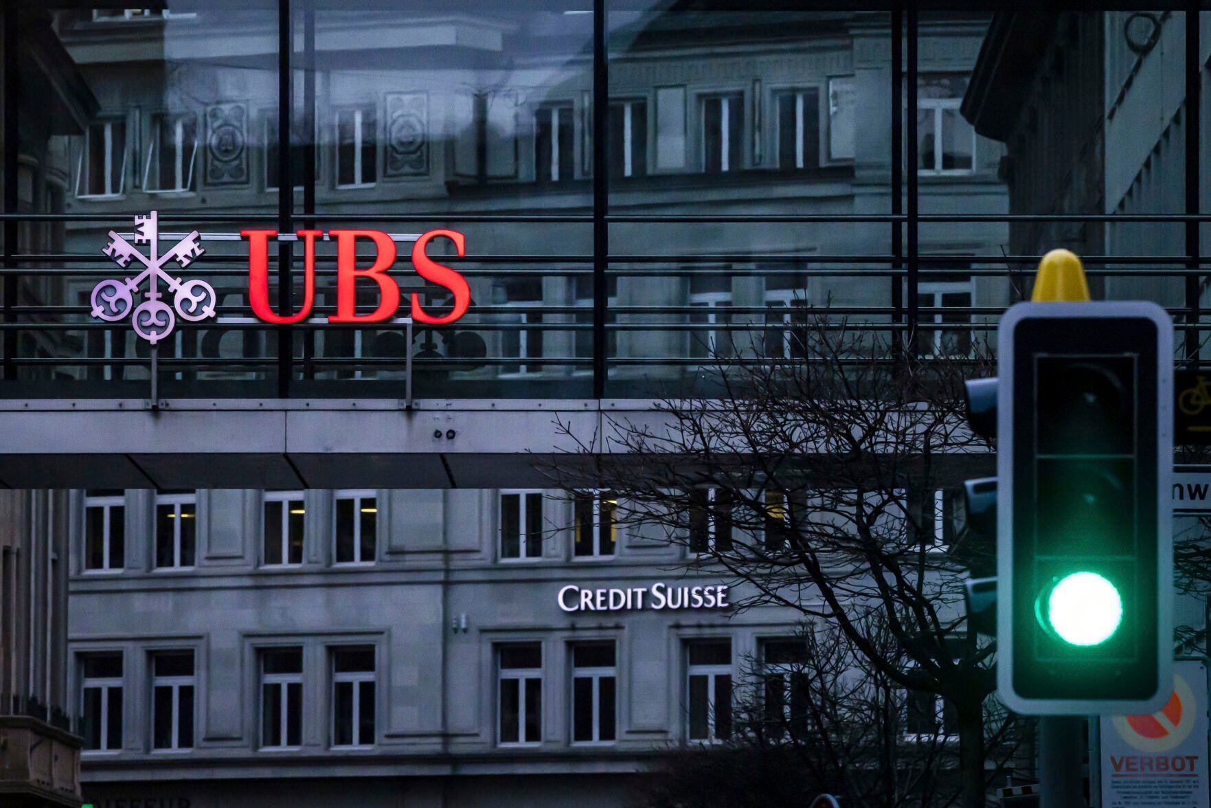 <p>A traffic light signals green in front of the logos of the Swiss banks Credit Suisse and UBS in Zurich, Switzerland, Sunday March 19, 2023. (Michael Buholzer/Keystone via AP)</p>   PHOTO CREDIT: Michael Buholzer