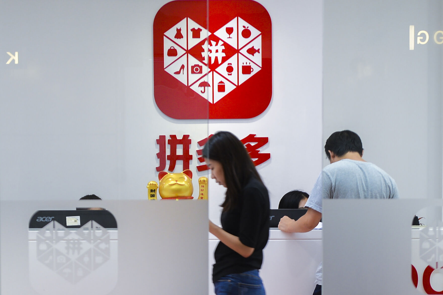 <p>A woman walks past the reception desk at the headquarters of Pinduoduo with the logo displayed in the background in Shanghai, on July 25, 2018. Google on Tuesday, March 21, 2023 has suspended the Chinese shopping app Pinduoduo on its app store after malware was discovered in versions of the app from other sources. (Chinatopix via AP)</p>   PHOTO CREDIT: CHINATOPIX