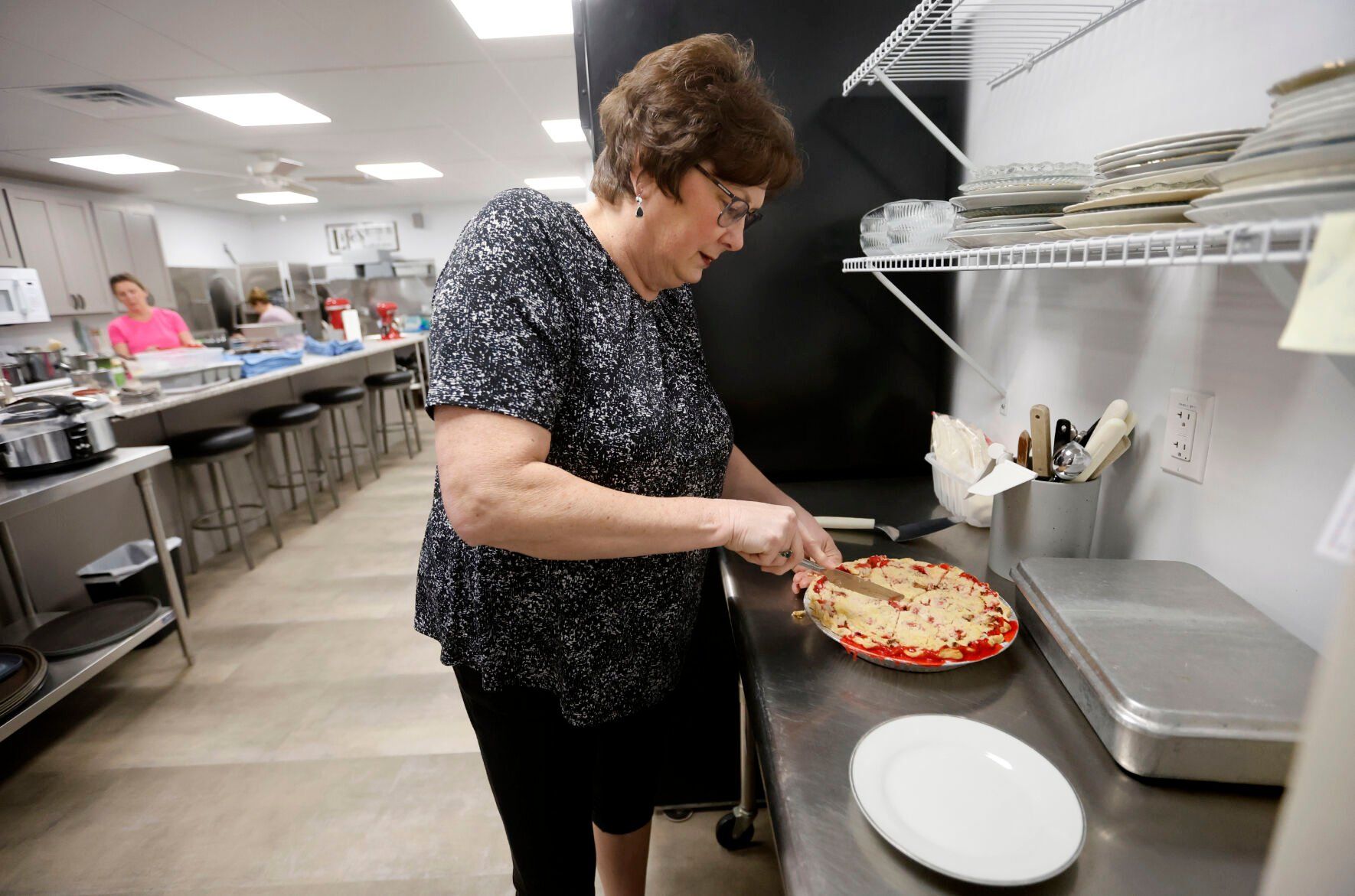 Owner Jackie Mormann cuts pie at The Bread Basket in Manchester, Iowa, on Thursday.    PHOTO CREDIT: JESSICA REILLY
