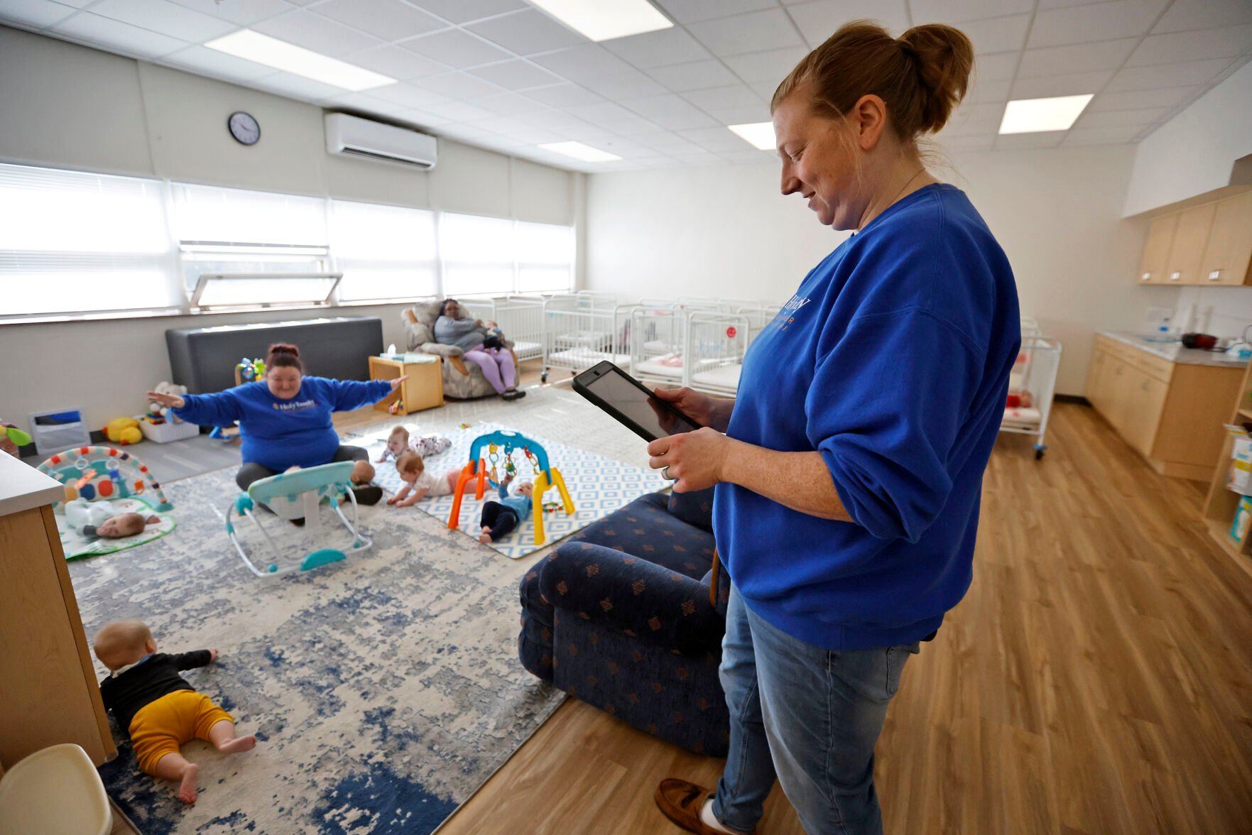 Alyssa Lawver, a child care associate, sends an update to a parent using the Procare app.    PHOTO CREDIT: JESSICA REILLY
Telegraph Herald