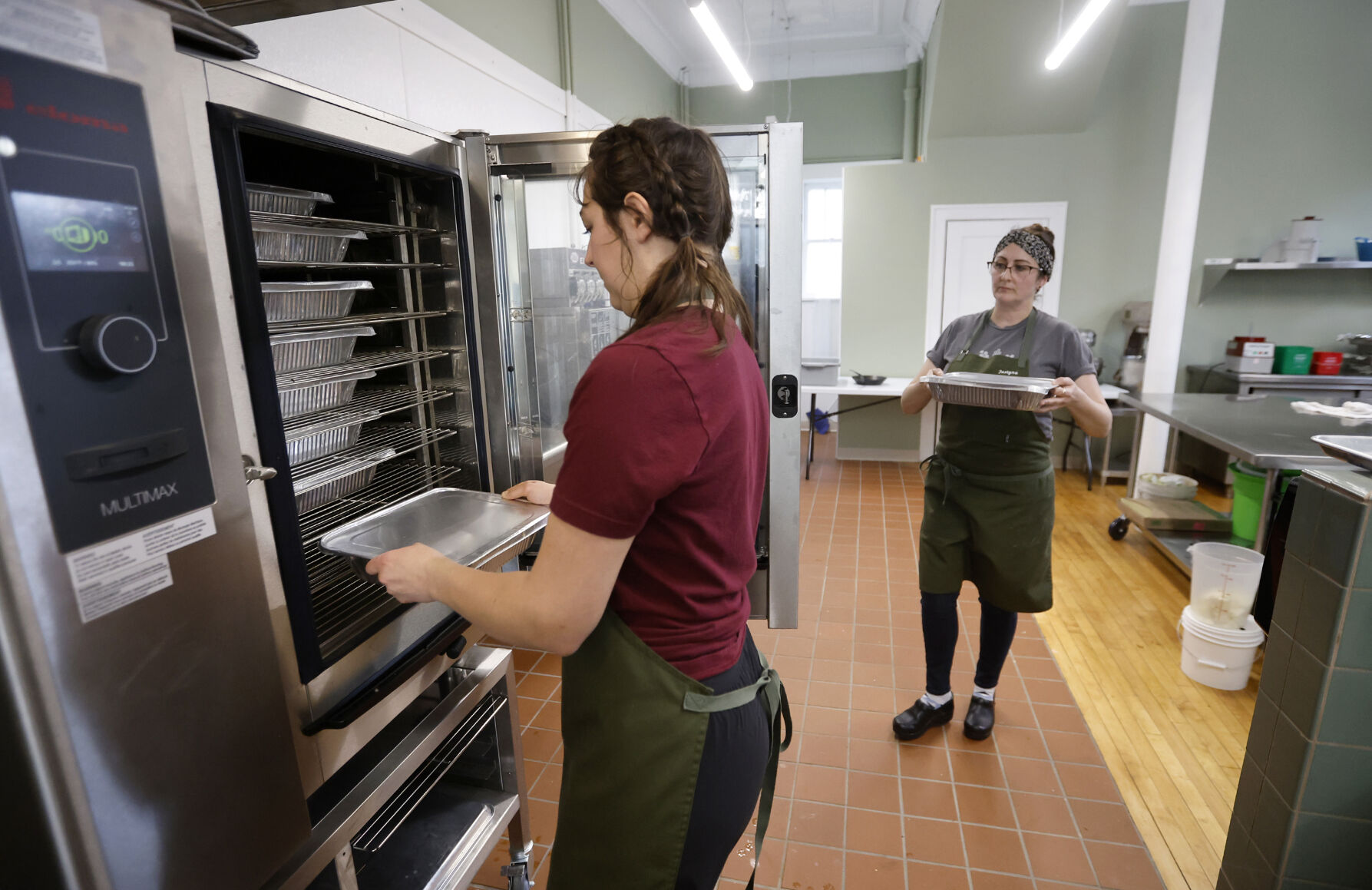 Monica Brehm (left) and owner Justyna Miranda prepare meals at City Girl Farming in Dubuque on Tuesday, April 11, 2023.    PHOTO CREDIT: JESSICA REILLY