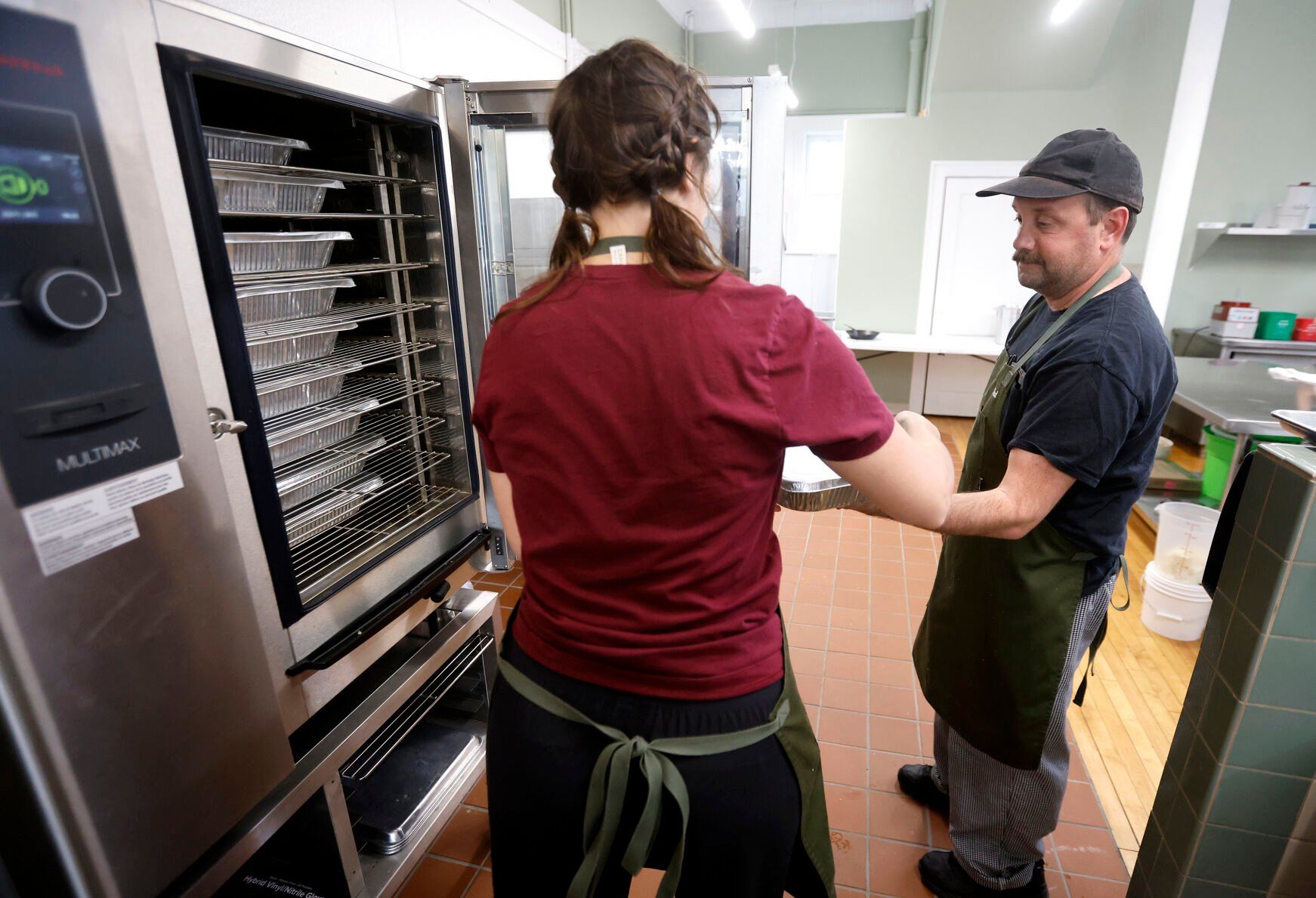 Monica Brehm (left) and Ted Ohlms prepare meals at City Girl Farming in Dubuque on Tuesday, April 11, 2023.    PHOTO CREDIT: JESSICA REILLY