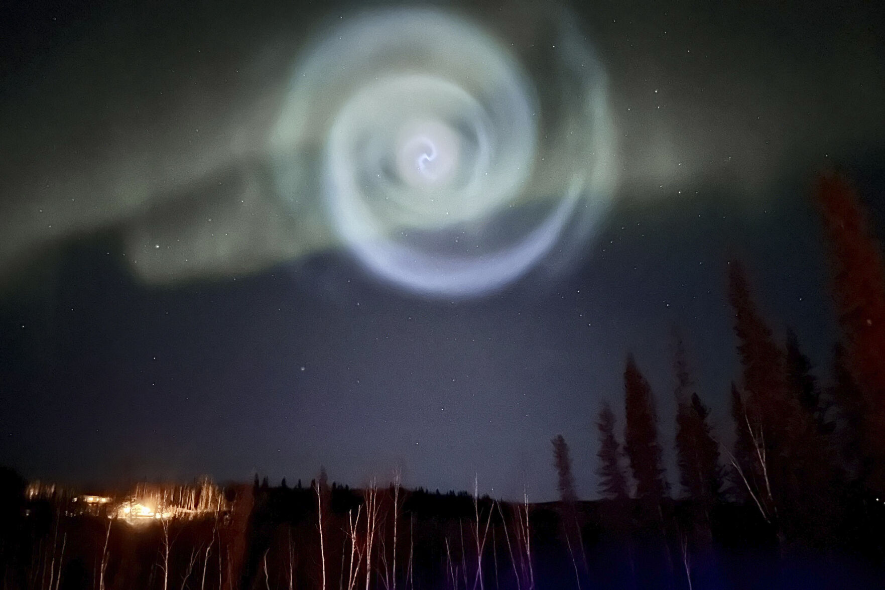 <p>In this photo provided by Christopher Hayden, a light baby blue spiral resembling a galaxy appears amid the aurora for a few minutes in the Alaska skies near Fairbanks, Saturday, April 15, 2023. The spiral was formed when excess fuel that had been released from a SpaceX rocket that launched from California about three hours earlier turned to ice, and then the water vapor reflected the sunlight in the upper atmosphere. (Christopher Hayden via AP)</p>   PHOTO CREDIT: Christopher Hayden - handout one time use, Christopher Hayden