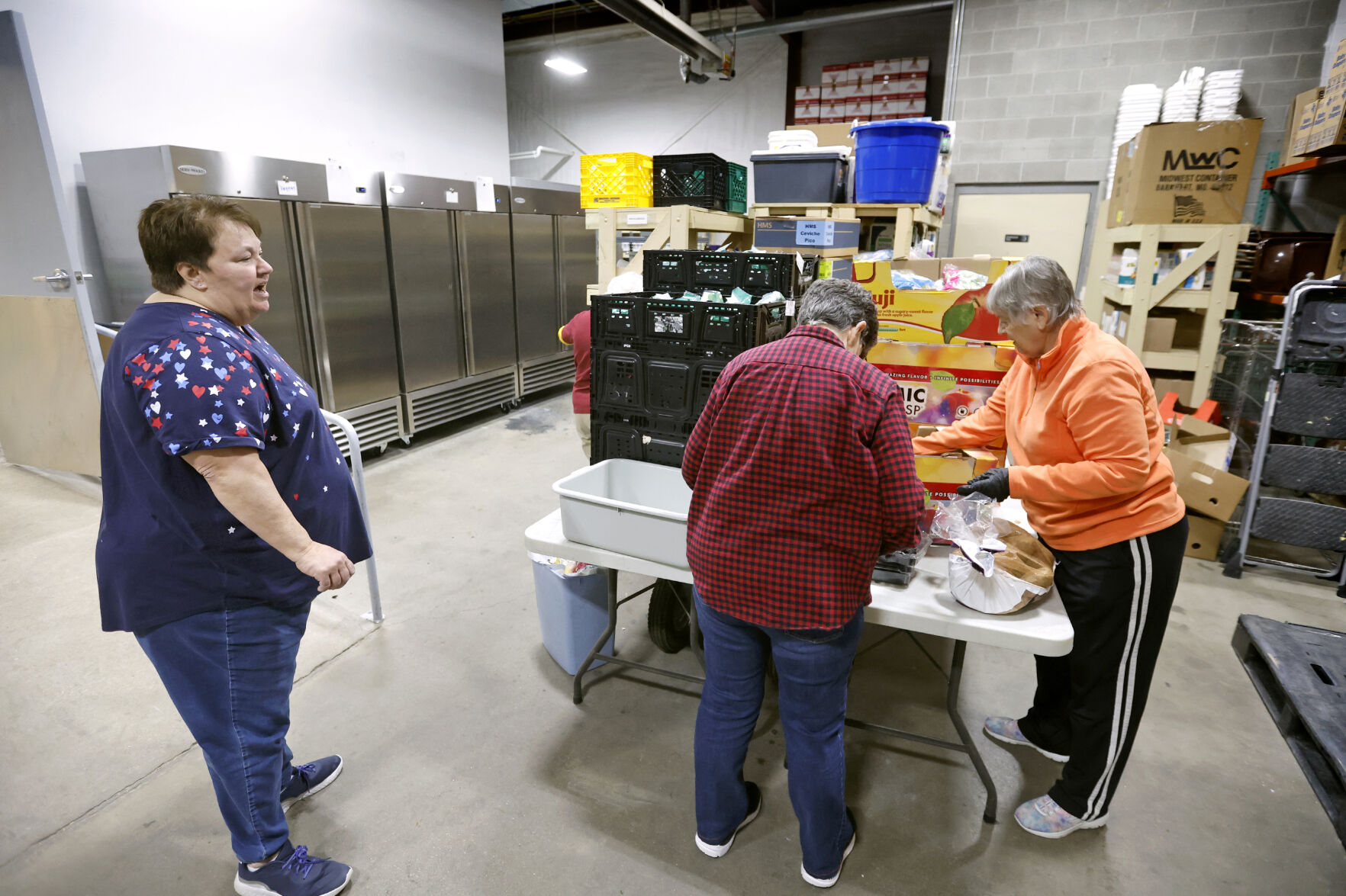 Theresa Caldwell (from left), executive director at Dubuque Food Pantry, talks with Sister Pat Farrell and Sister Nancy Meyerhofer at the facility in Dubuque.    PHOTO CREDIT: Jessica Reilly