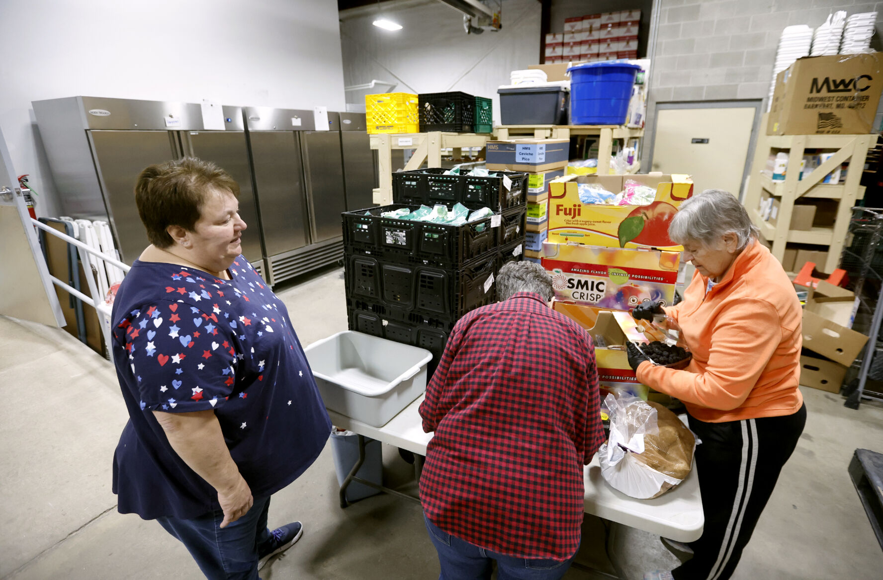 Theresa Caldwell (from left), executive director at Dubuque Food Pantry, talks with Sister Pat Farrell and Sister Nancy Meyerhofer at the facility in Dubuque.    PHOTO CREDIT: Jessica Reilly