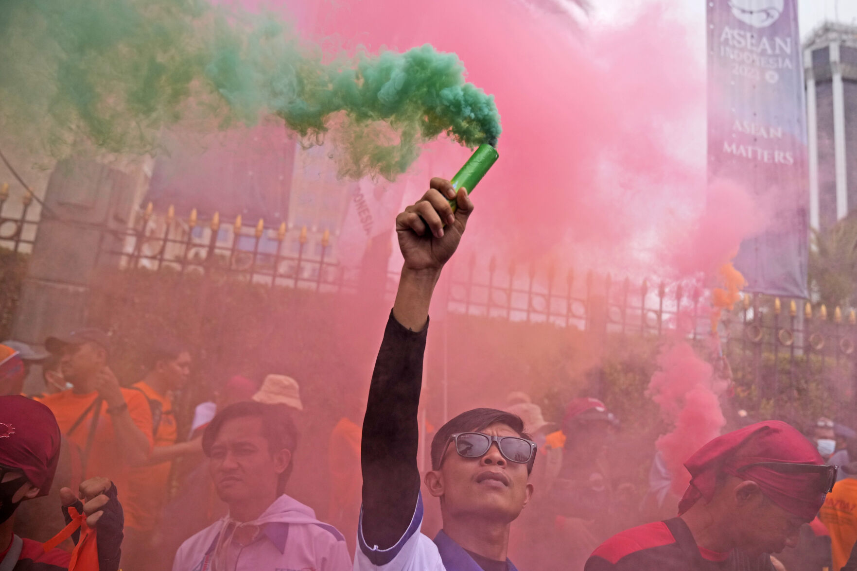 <p>A worker holds up a smoke stick during a May Day rally in Jakarta, Indonesia, Monday, May 1, 2023. Workers and activists across Asia are marking May Day with protests calling for higher salaries and better working conditions, among other demands. (AP Photo/Dita Alangkara)</p>   PHOTO CREDIT: Dita Alangkara 