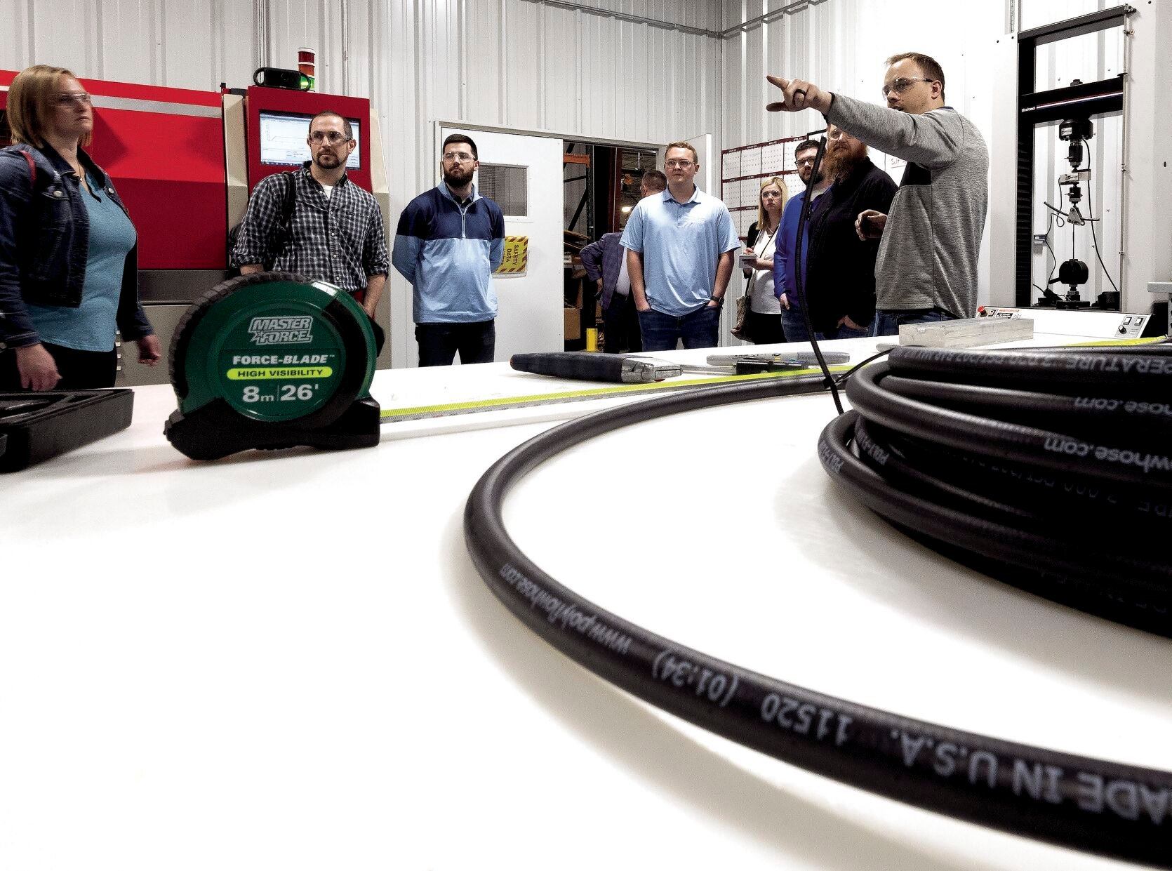 New Product Development Engineer Evan Kuhl (right) speaks with participants in a tour at ProPulse in Peosta, Iowa, as part of Manufacturing Appreciation Week on Tuesday.    PHOTO CREDIT: Stephen Gassman