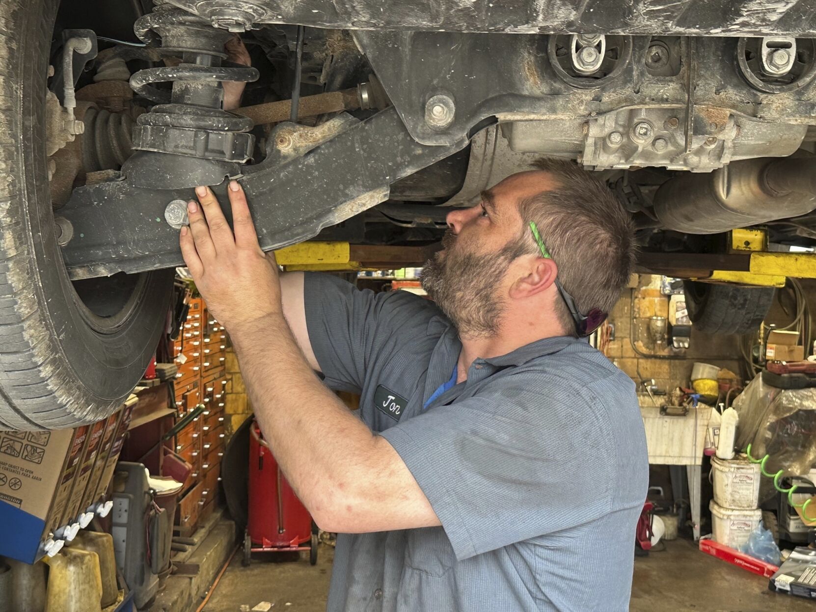 <p>Mechanic Jon Guthrie inspects the underside of a 2014 Honda Ridgeline pickup truck at Japanese Auto Professional Service in Ann Arbor, Michigan. People are keeping their vehicles longer due to shortages of new ones and high prices. That drove the average U.S. vehicle age up to a record 12.5 years in 2022, according to S&P Global Mobility. (AP Photo/Tom Krisher)</p>   PHOTO CREDIT: Tom Krisher 