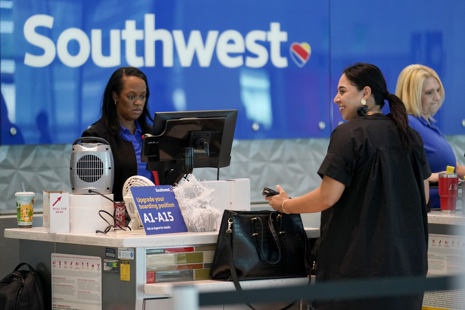 <p>A Southwest airlines customer service representative, left, assists a traveler at the ticketing counter at Love Field airport, Friday, May 19, 2023, in Dallas. The unofficial start of the summer travel season is here, with airlines hoping to avoid the chaos of last year and travelers scrounging for ways to save a few bucks on pricey airfares and hotel rooms.(AP Photo/Tony Gutierrez)</p>   PHOTO CREDIT: Tony Gutierrez 