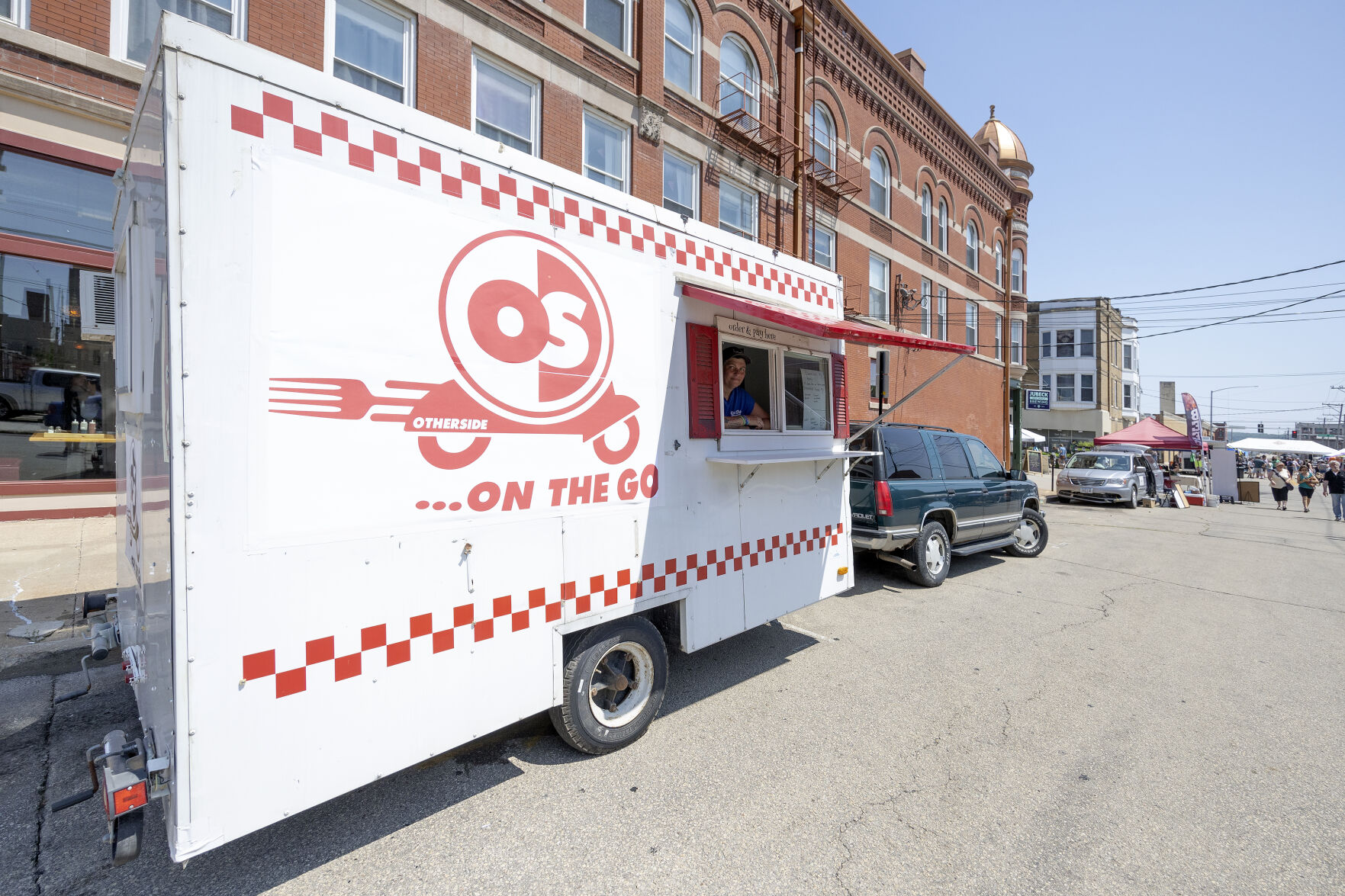 Owner Michelle Mulgrew looks out of her food truck, Other Side On The Go, while at the Dubuque Farmers Market on Saturday, June 3, 2023.    PHOTO CREDIT: Stephen Gassman