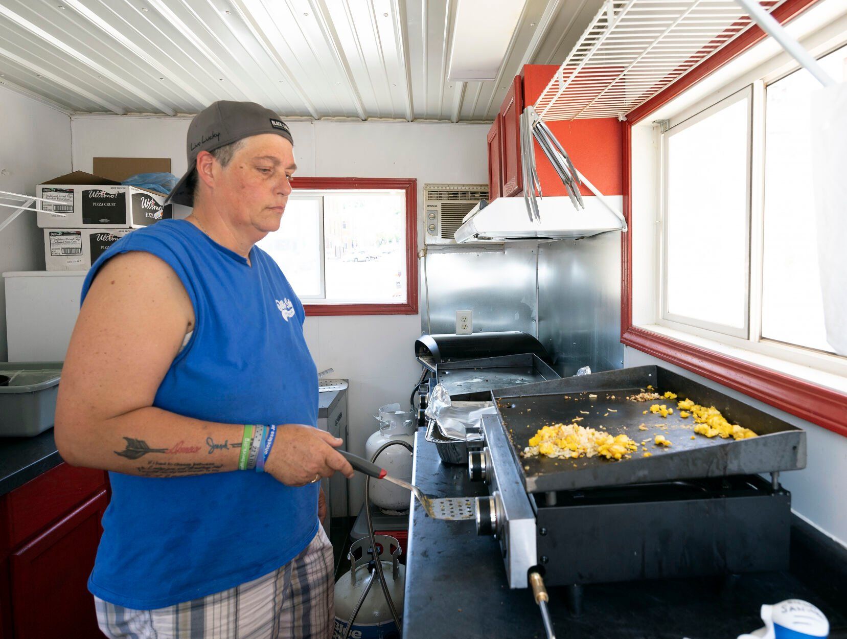 Owner Michelle Mulgrew prepares breakfast in her food truck, Other Side On The Go, while at the Dubuque Farmers Market on Saturday.    PHOTO CREDIT: Stephen Gassman